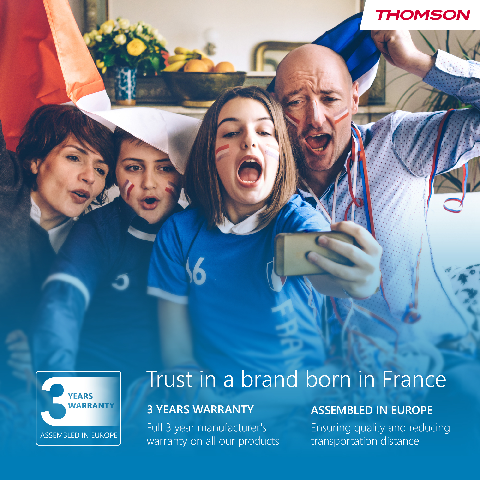 Quattro persone con bandiere francesi e trucco facciale. Una persona tiene un telefono, a bocca aperta. Logo Thomson presente.