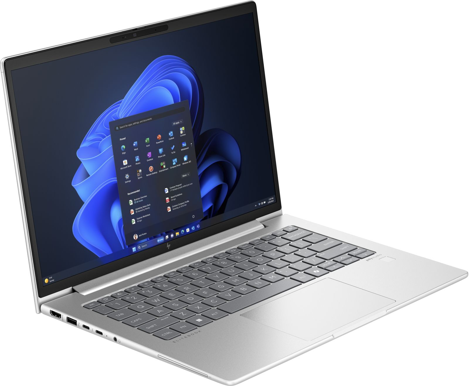 Srebrny laptop, ekran Windows z aplikacjami. Widoczna klawiatura i touchpad. Laptop jest lekko pochylony.