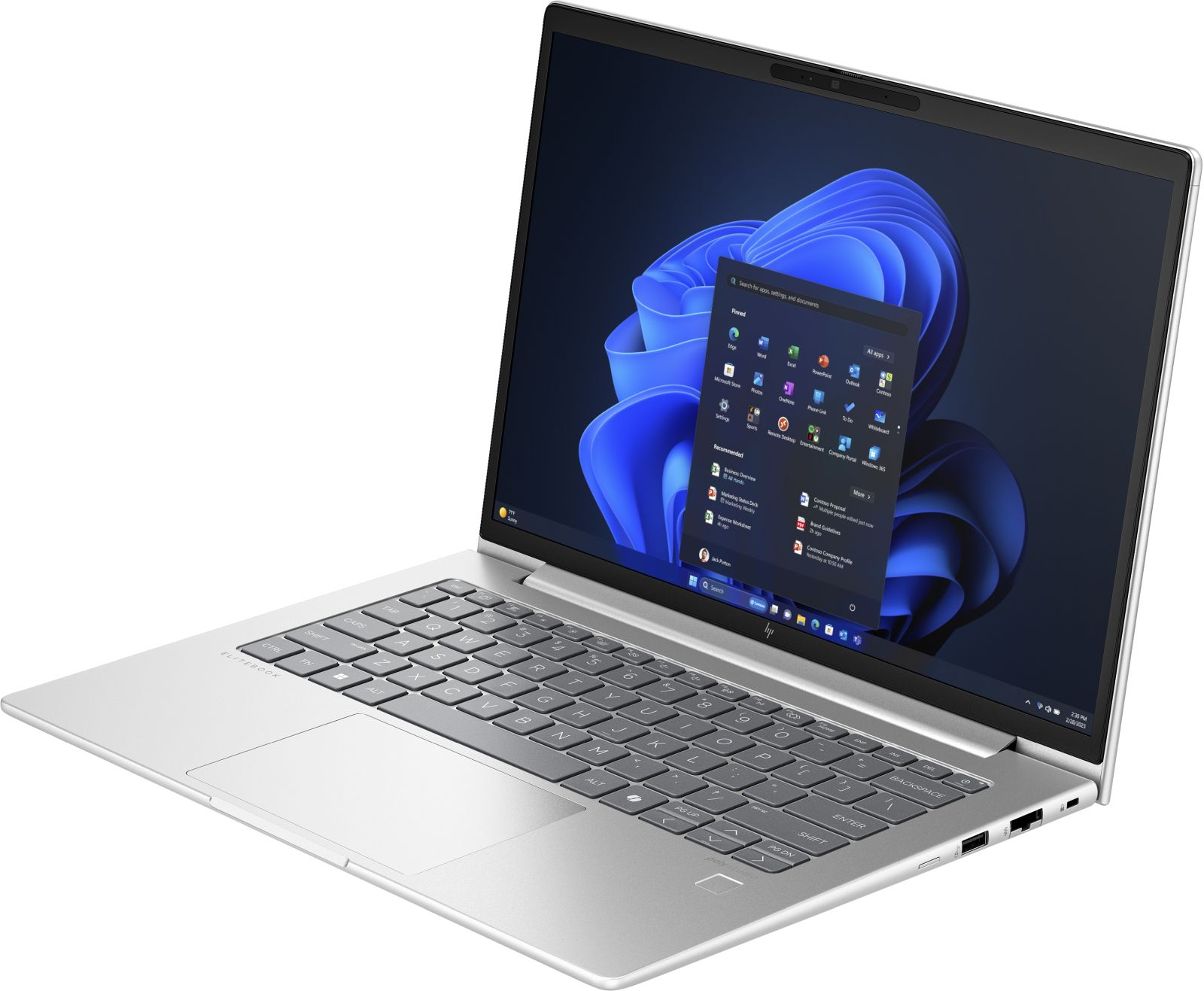 Srebrny laptop, ekran Windows z aplikacjami. Widoczna klawiatura i touchpad. Laptop jest lekko pochylony.