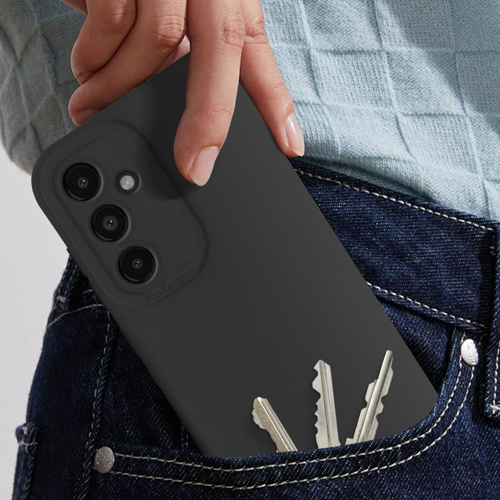 Una custodia nera per telefono in tasca di jeans con tre chiavi d'argento.