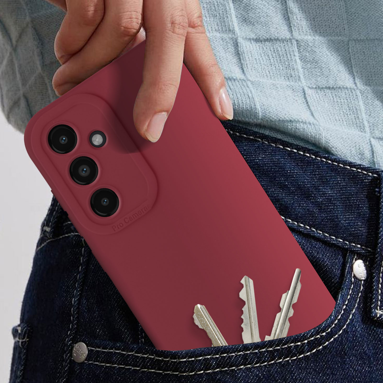 Eine rote Handyhülle mit einem Handy in einer Jeanstasche. Schlüssel sind sichtbar.