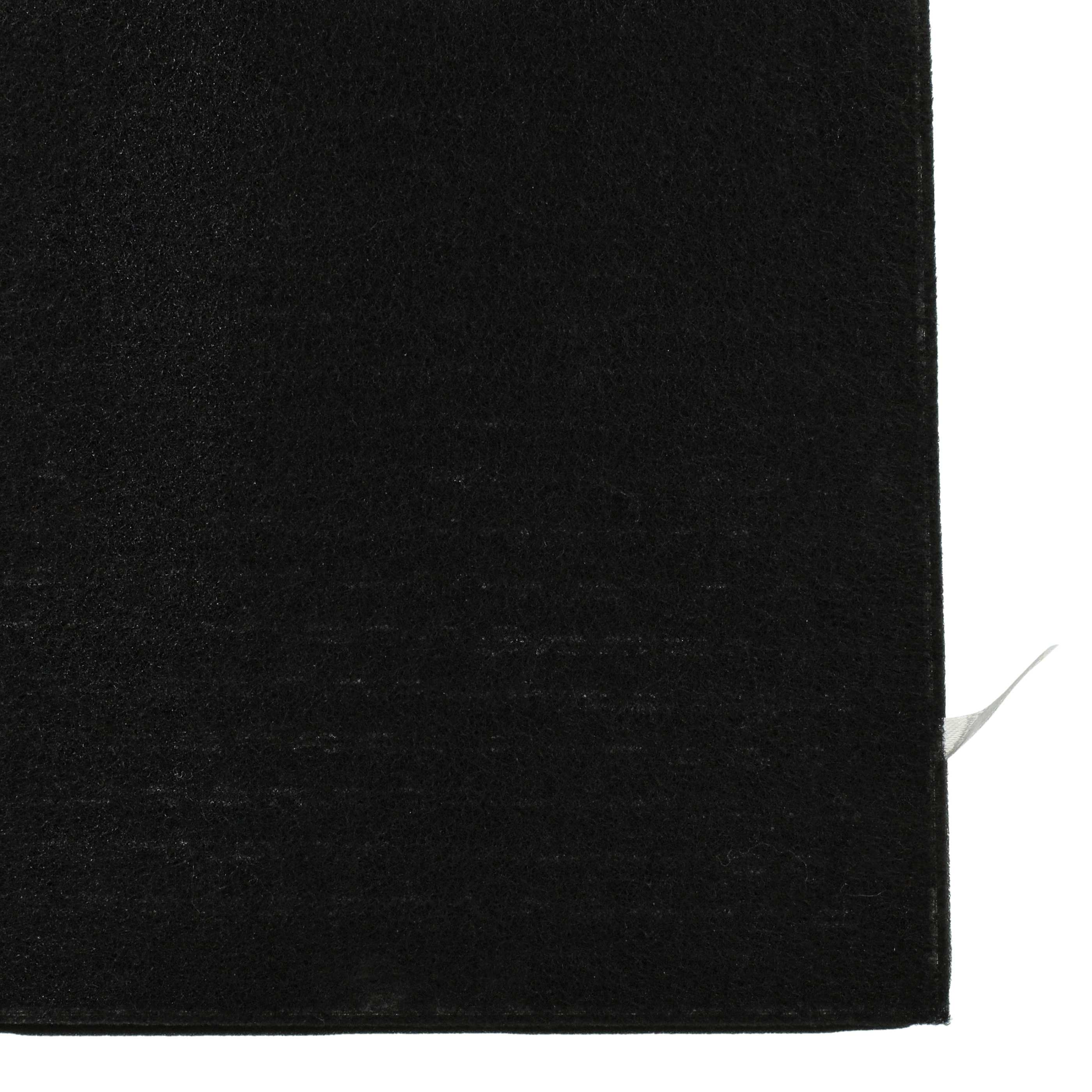 Nahaufnahme eines schwarzen Stoffes, wahrscheinlich eine Matte oder Abdeckung, Ecke sichtbar.