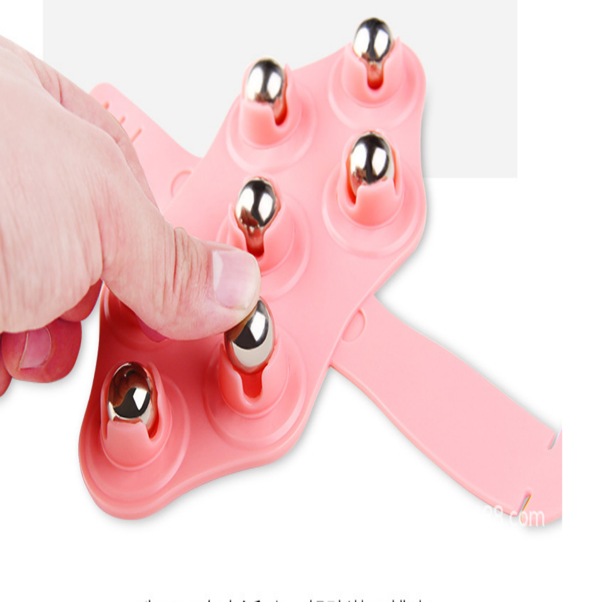 Rosa Handmassagegerät mit silbernen Kugeln, die von einem Finger gedrückt werden.