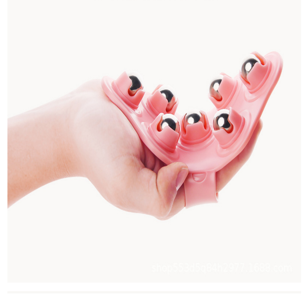 Eine Hand, die ein rosa Massagegerät mit silbernen Kugeln hält.