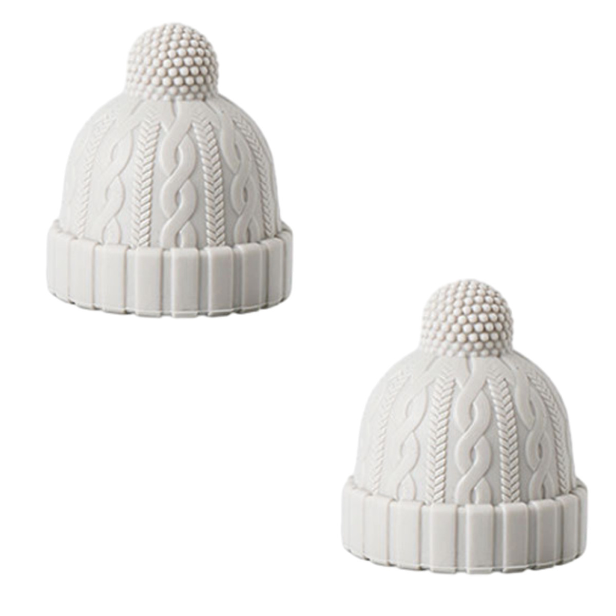 Zwei weiße Deko-Hüte im Strickmuster. Sie haben einen Bommel oben drauf.