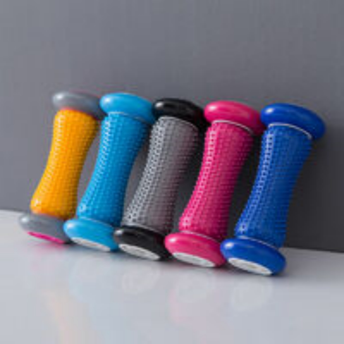 Fünf farbige Fußroller. Blau, rosa, schwarz, blau und gelb.