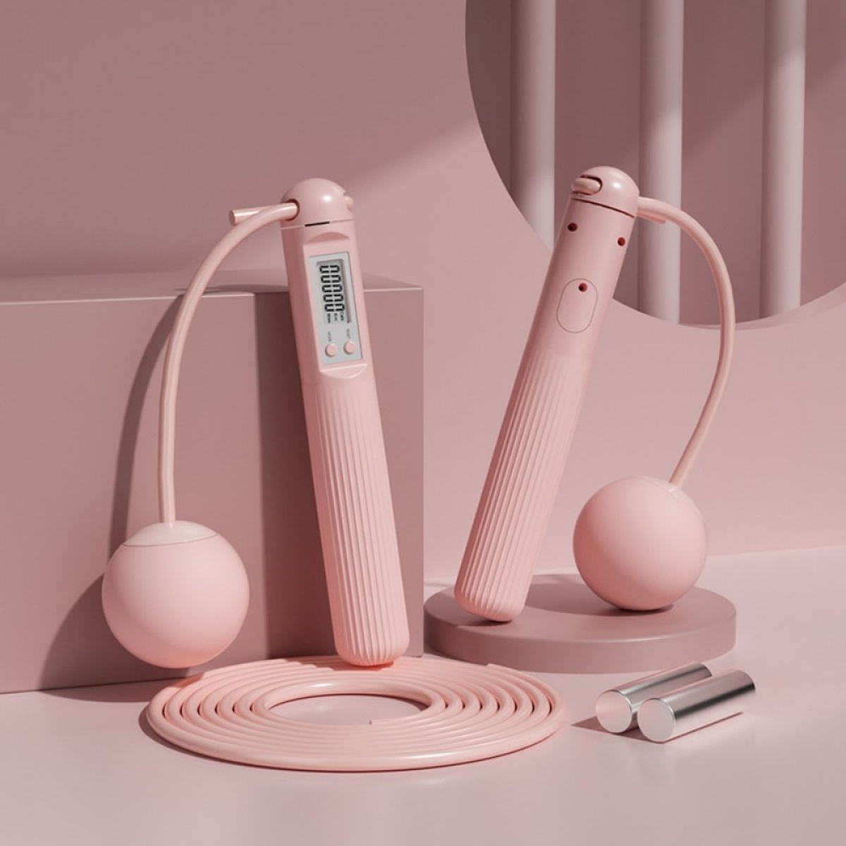 Zwei rosa Springseile, eines mit Digitalanzeige, und ein rosa Hintergrund. Zwei silberne Gewichte sind ebenfalls vorhanden.