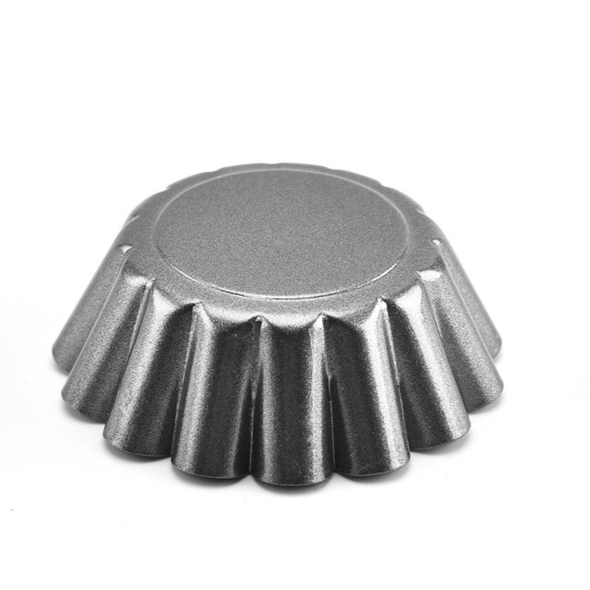 Eine graue, geriffelte Tarteform, isoliert auf weißem Hintergrund.