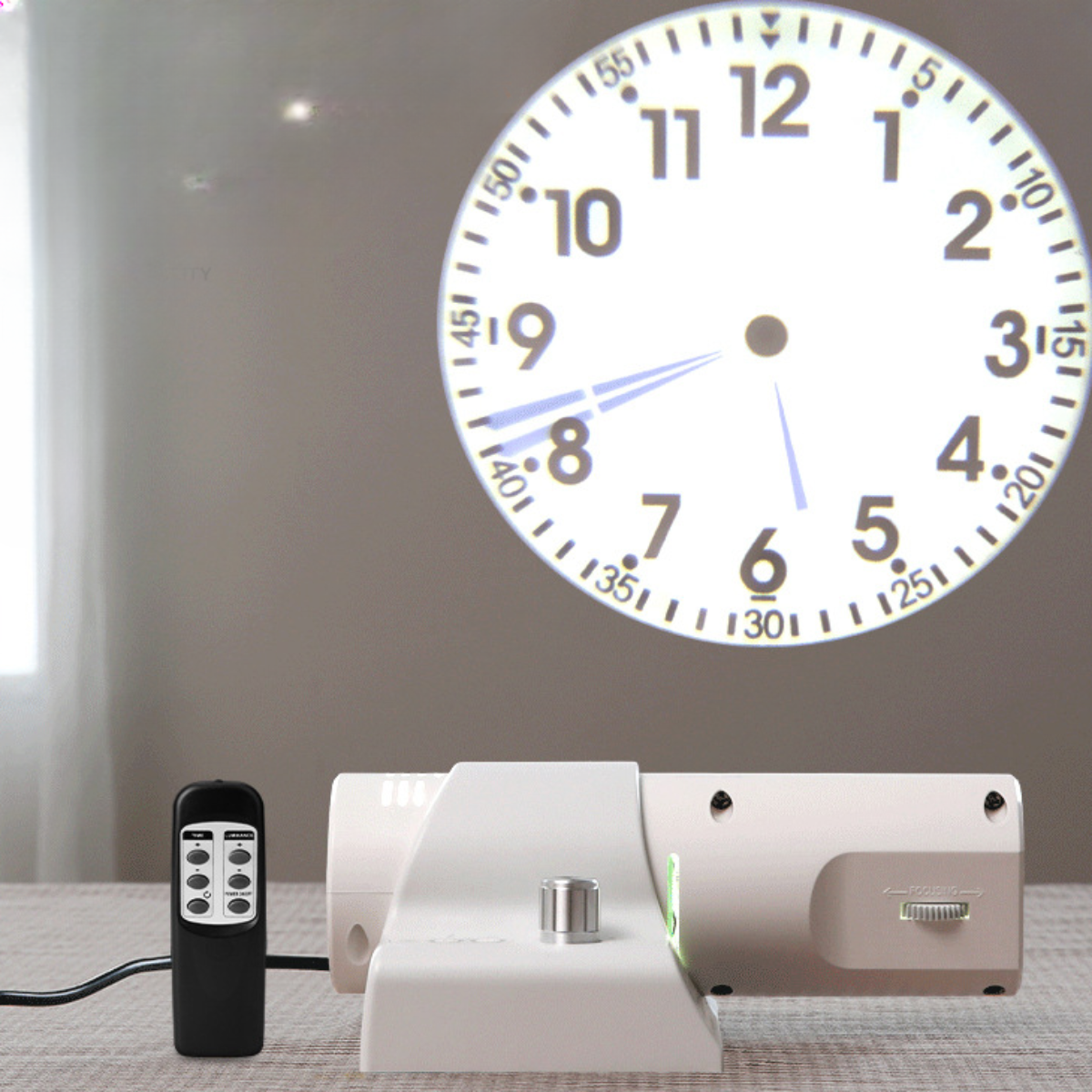 Eine Uhr, die auf eine Wand projiziert wird, mit einer Fernbedienung und einem weißen Projektor. Die Uhr zeigt die Zeit.
