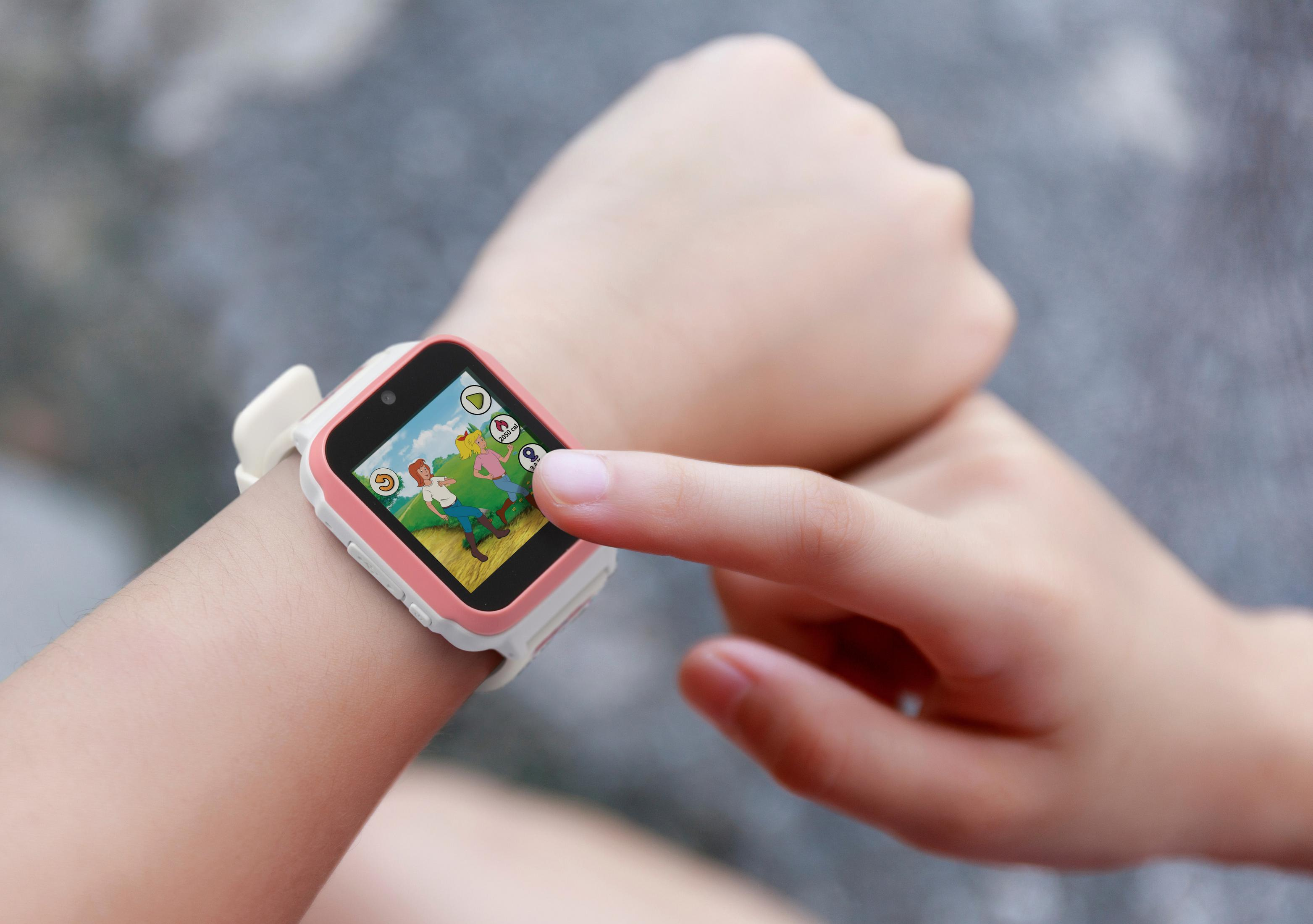 Kinderhand zeigt auf Smartwatch-Bildschirm. Uhr zeigt animierte Szene.