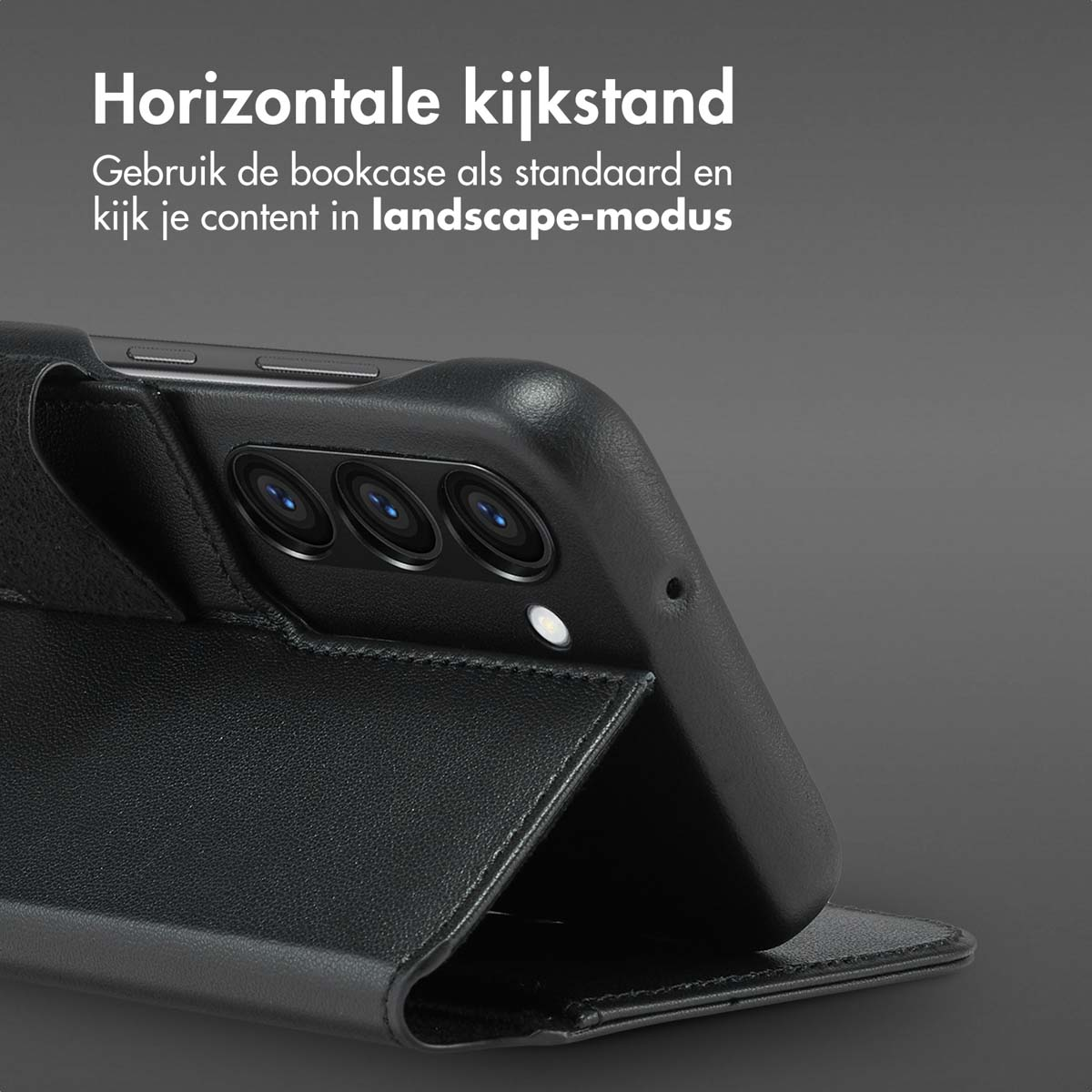 Zwarte telefoon in een zwarte hoes, in liggende positie, op een donkere achtergrond.