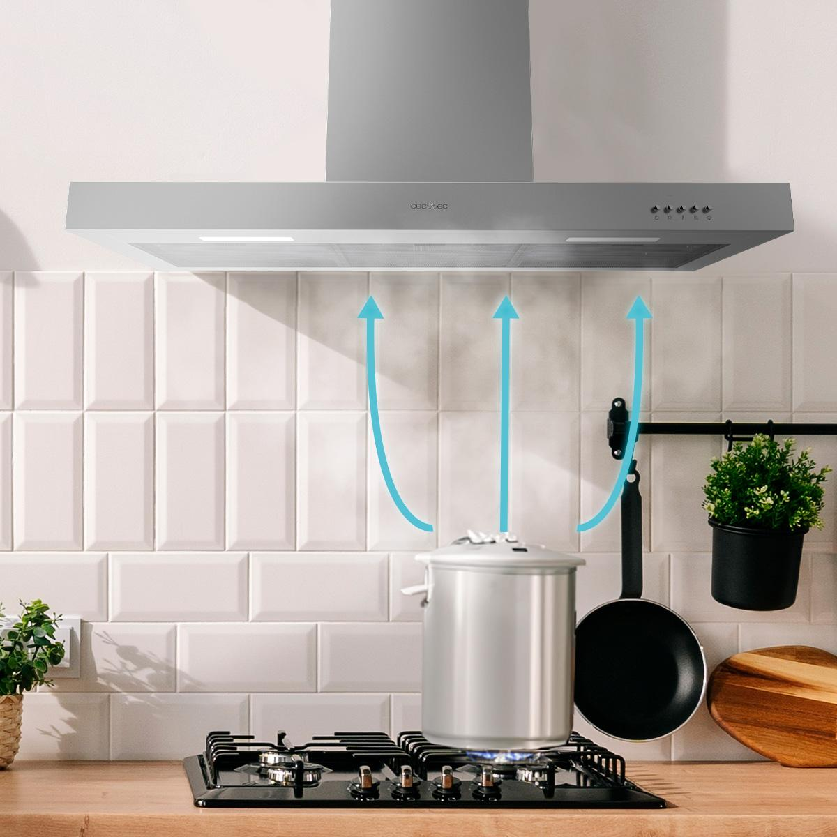 Cocina con campana extractora de acero inoxidable sobre una estufa con olla y sartén.