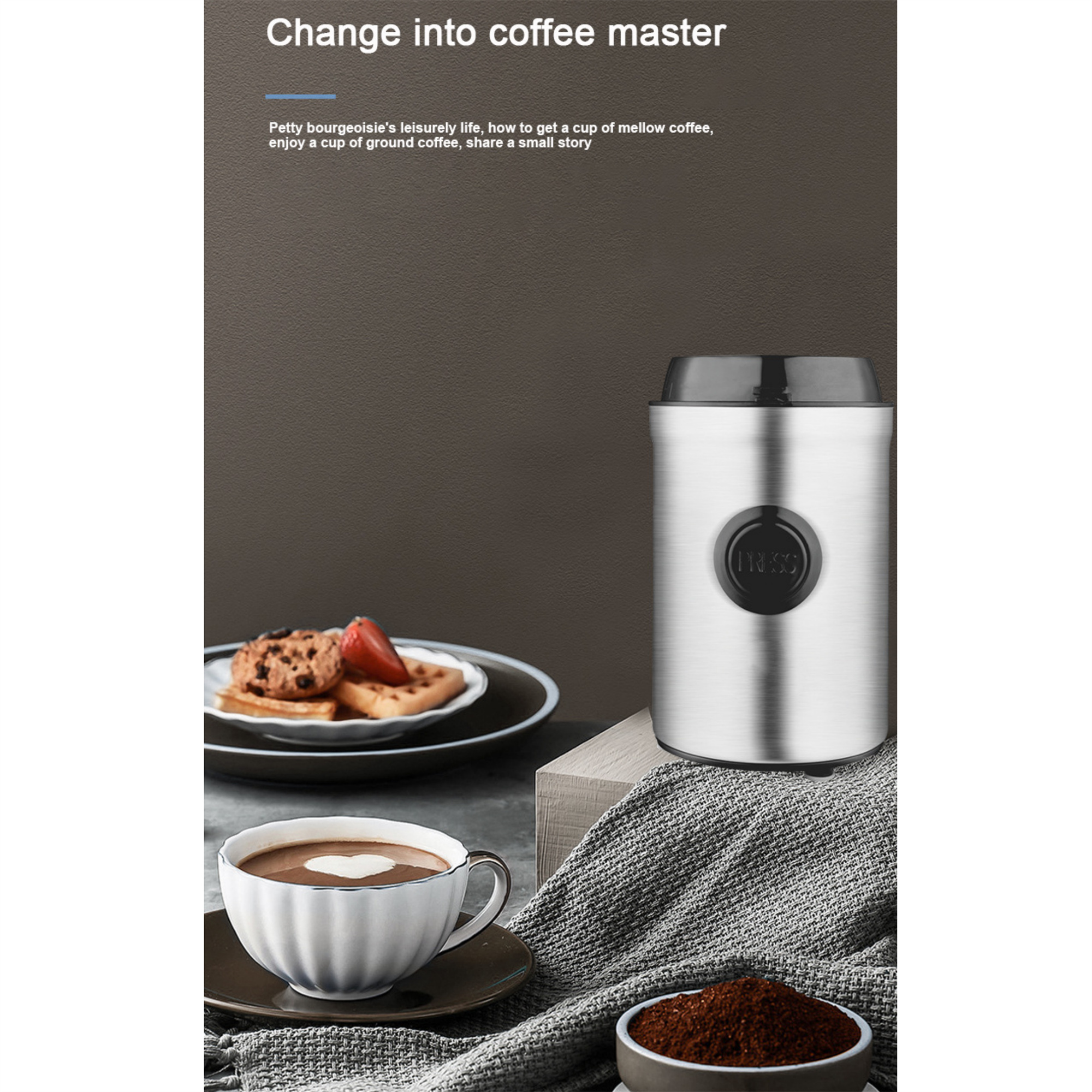 Kaffeemühle aus Edelstahl, Kaffeetasse, Kaffeepulver und Kekse auf einem Tisch.