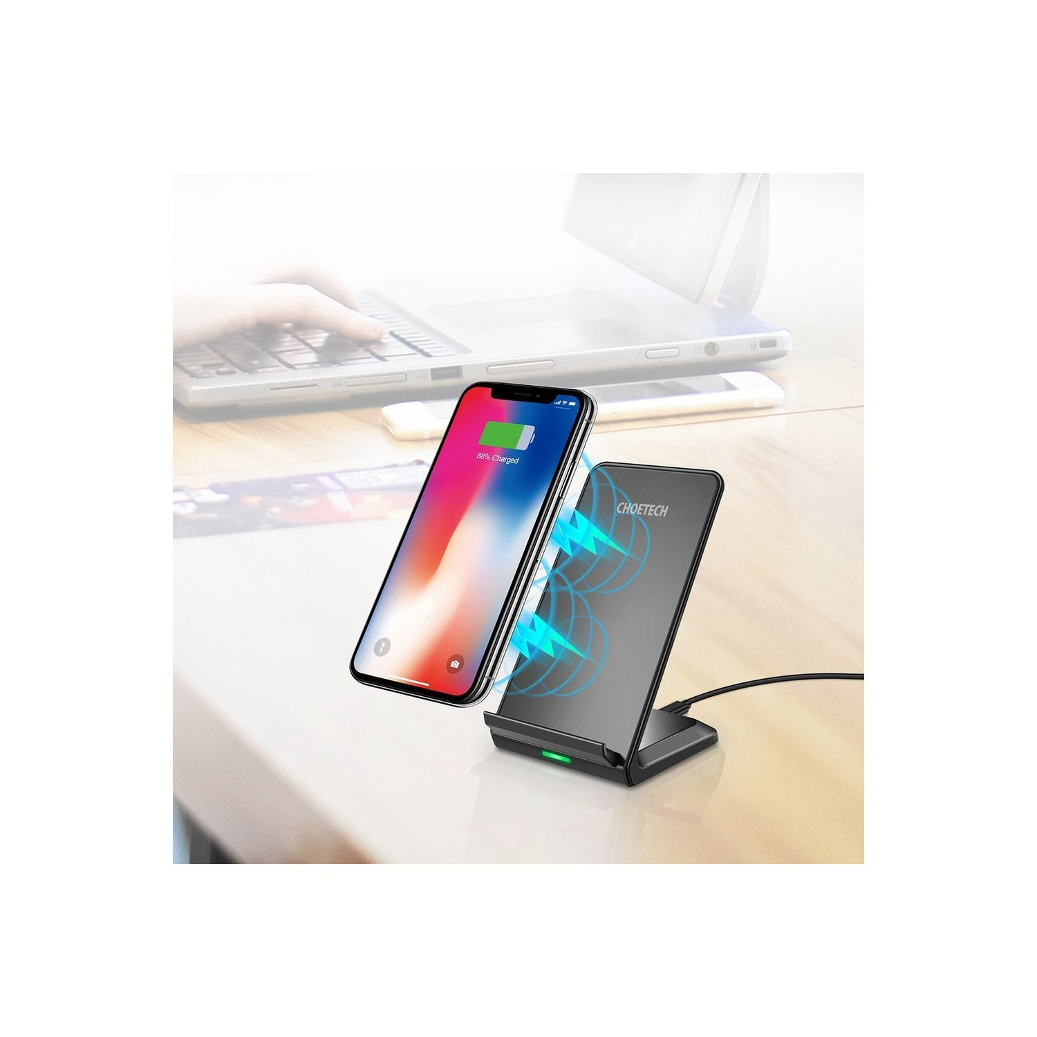 Telefon, das auf einem kabellosen Ladegerät lädt und den Batteriestand anzeigt. Im Hintergrund ist ein Laptop zu sehen.