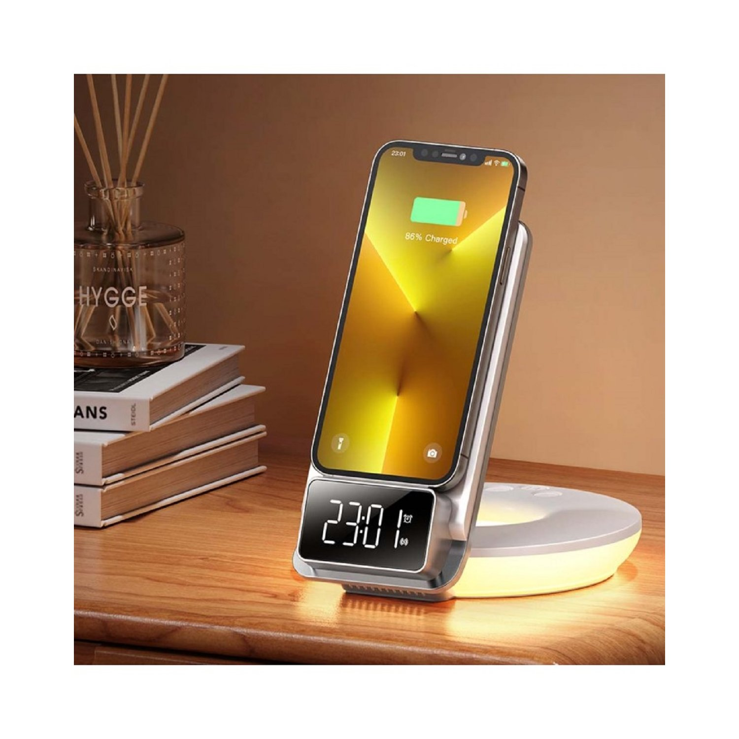 Kabelloses Ladegerät mit Telefon, Uhr und Schreibtischdeko. Telefon zeigt Ladestatus.