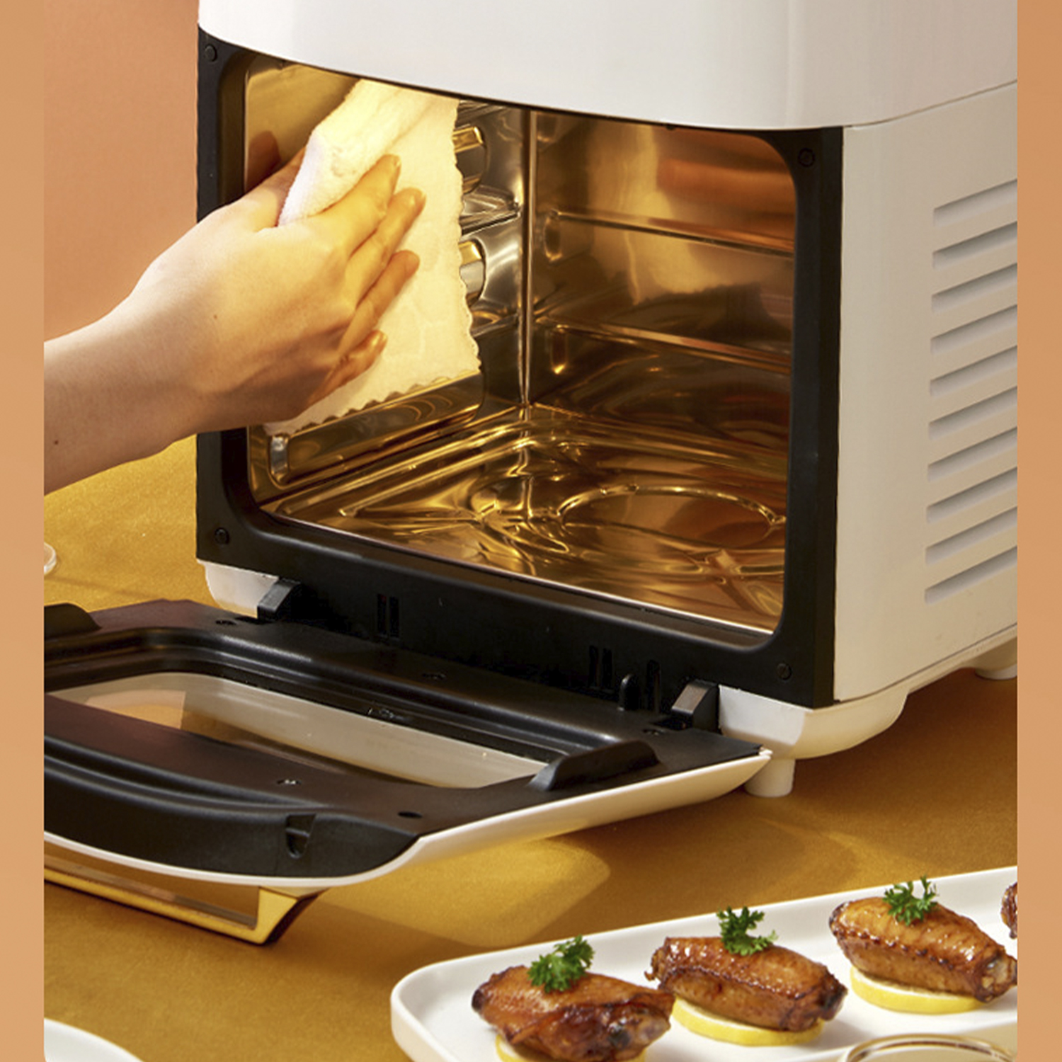 Donna che pulisce l'interno di un forno con un asciugamano. Cibo fritto su un piatto in primo piano.