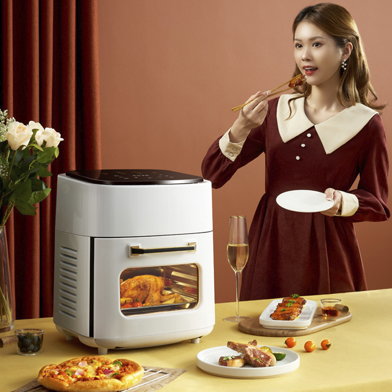 Una friggitrice ad aria con un pollo arrosto dentro, una donna con bacchette e un piatto.