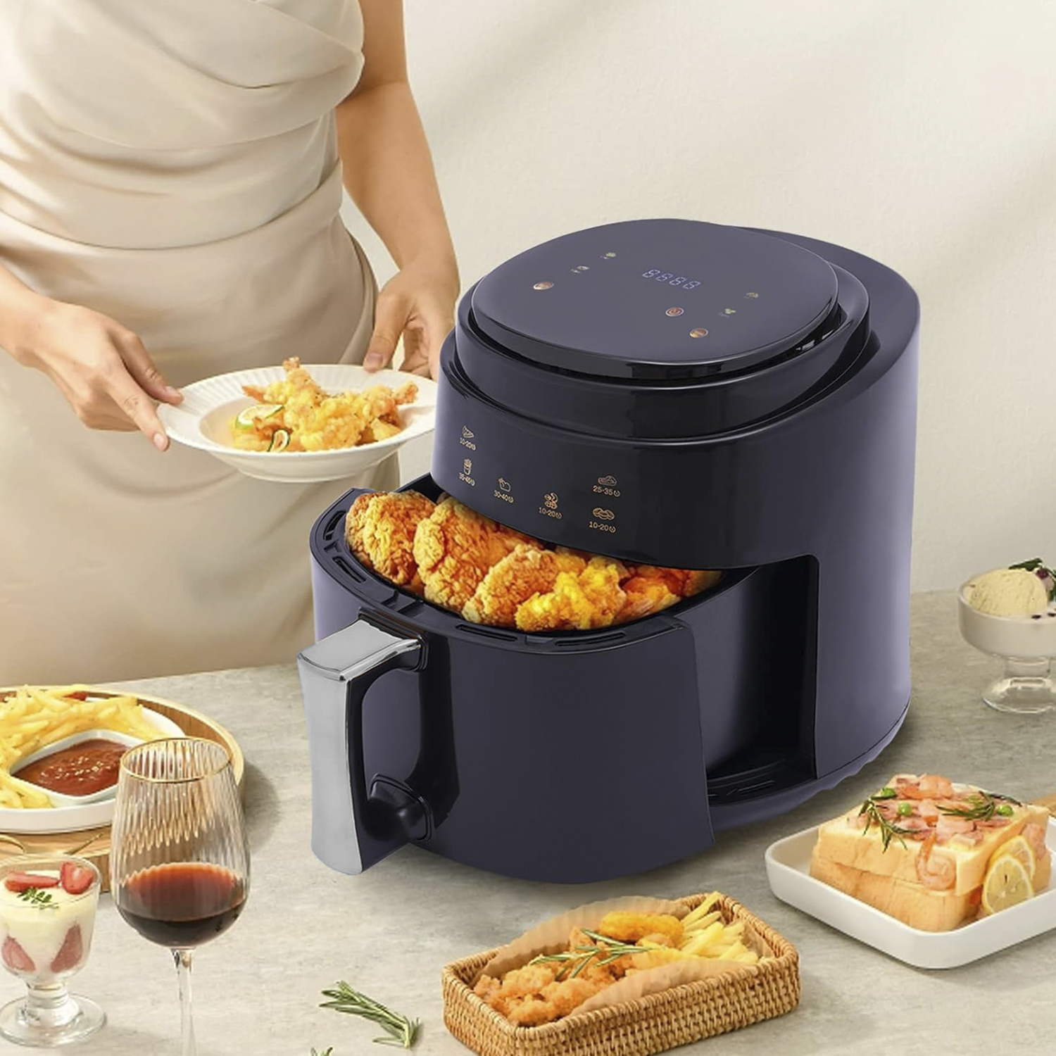 Una friggitrice ad aria con cibo cotto all'interno. Una donna tiene in mano un piatto di cibo fritto. Altri piatti sullo sfondo.