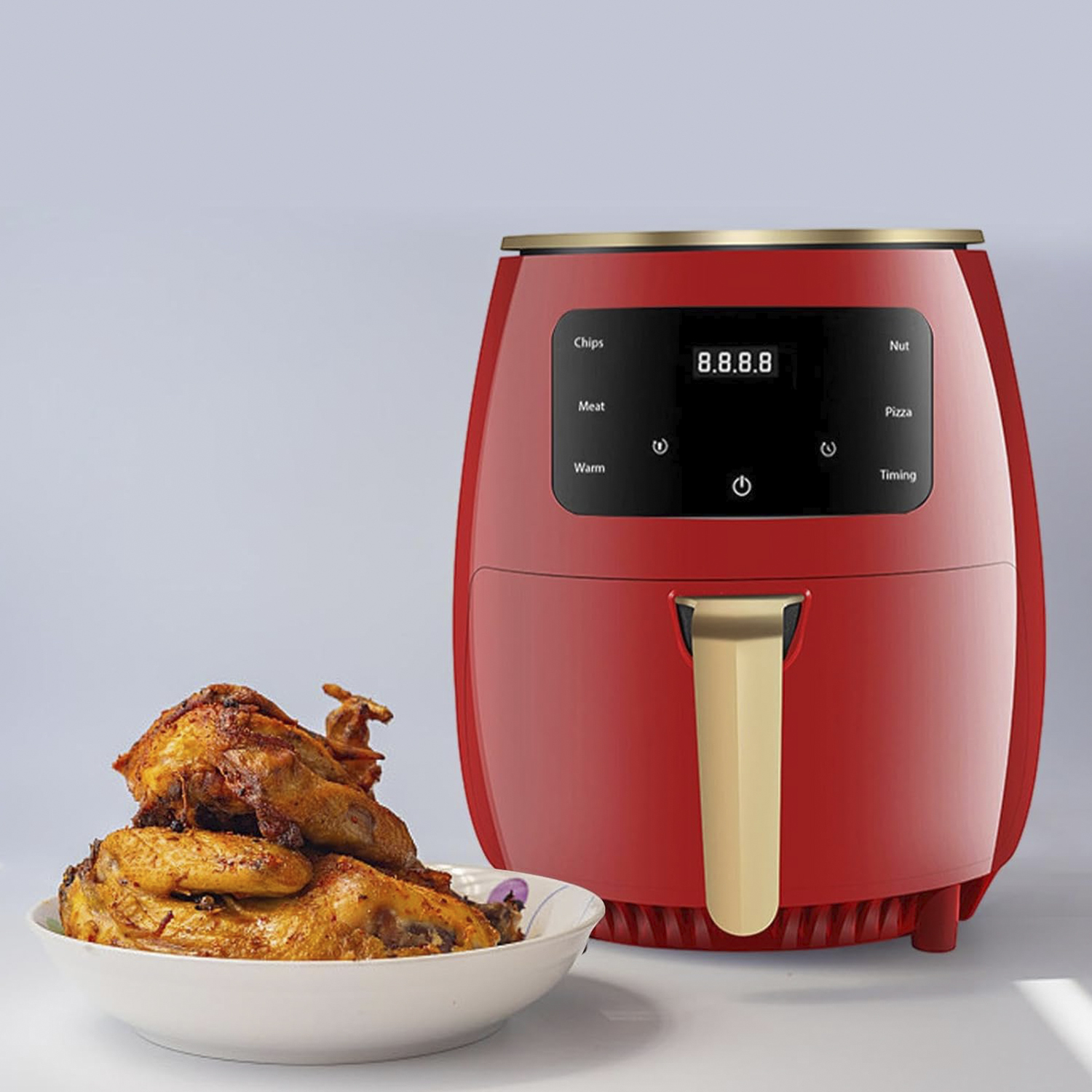 Roter Luftfritteuse mit Huhn und einer Schüssel davor. Hat Bedienfeld und goldene Akzente.