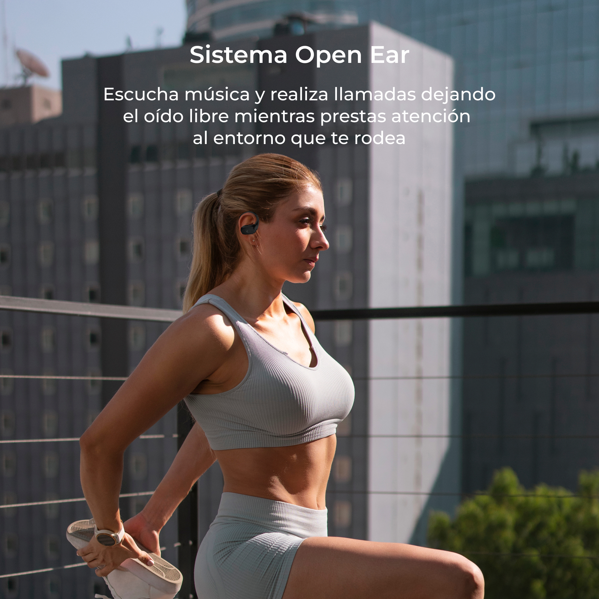 Kobieta w słuchawkach rozciąga się na zewnątrz, w pobliżu budynku.