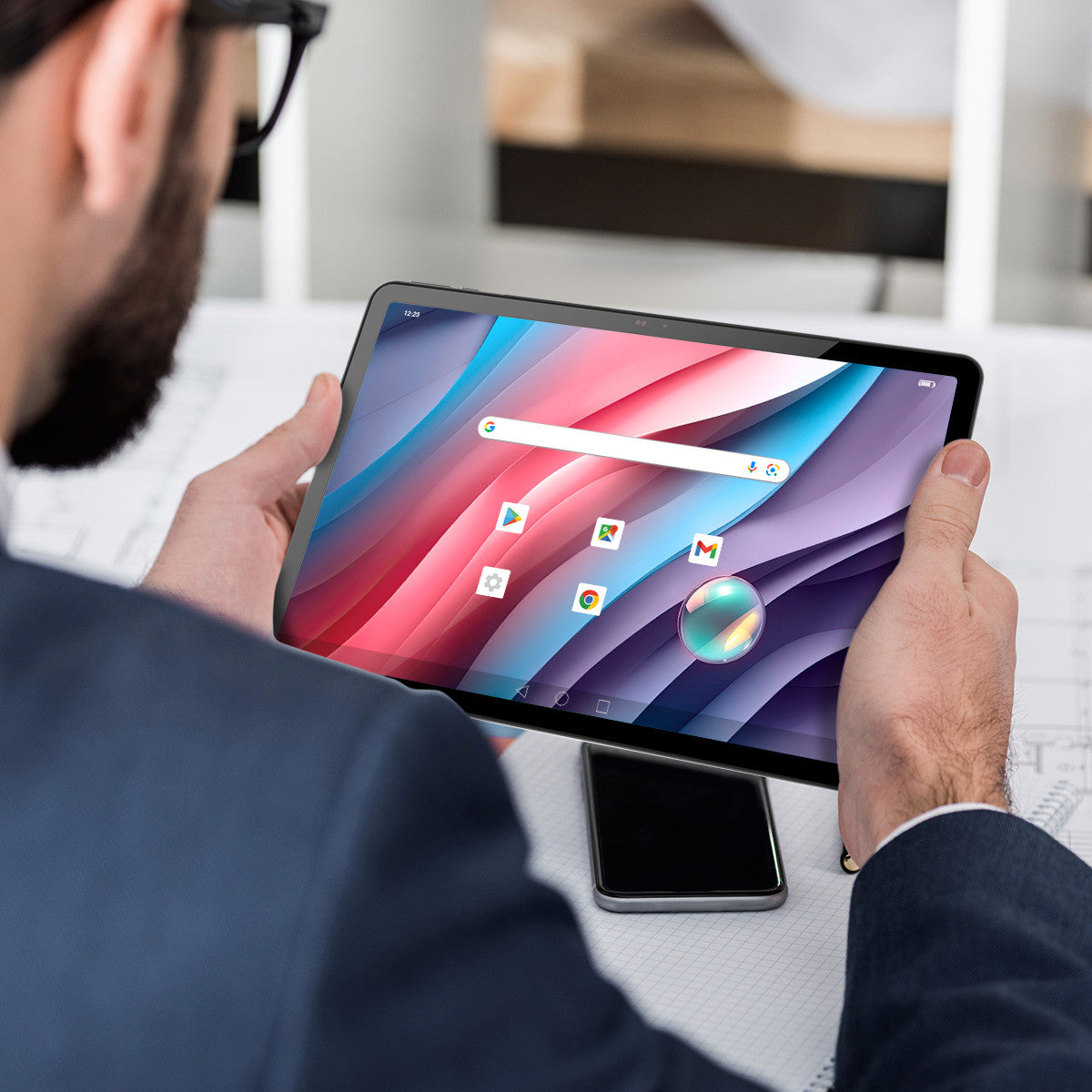 Una persona che tiene un tablet. Lo schermo mostra un'interfaccia colorata con icone.