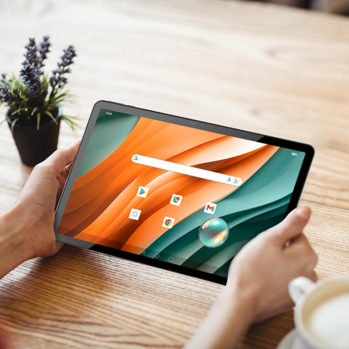 Persona che tiene un tablet con icone e grafica, su un tavolo di legno.