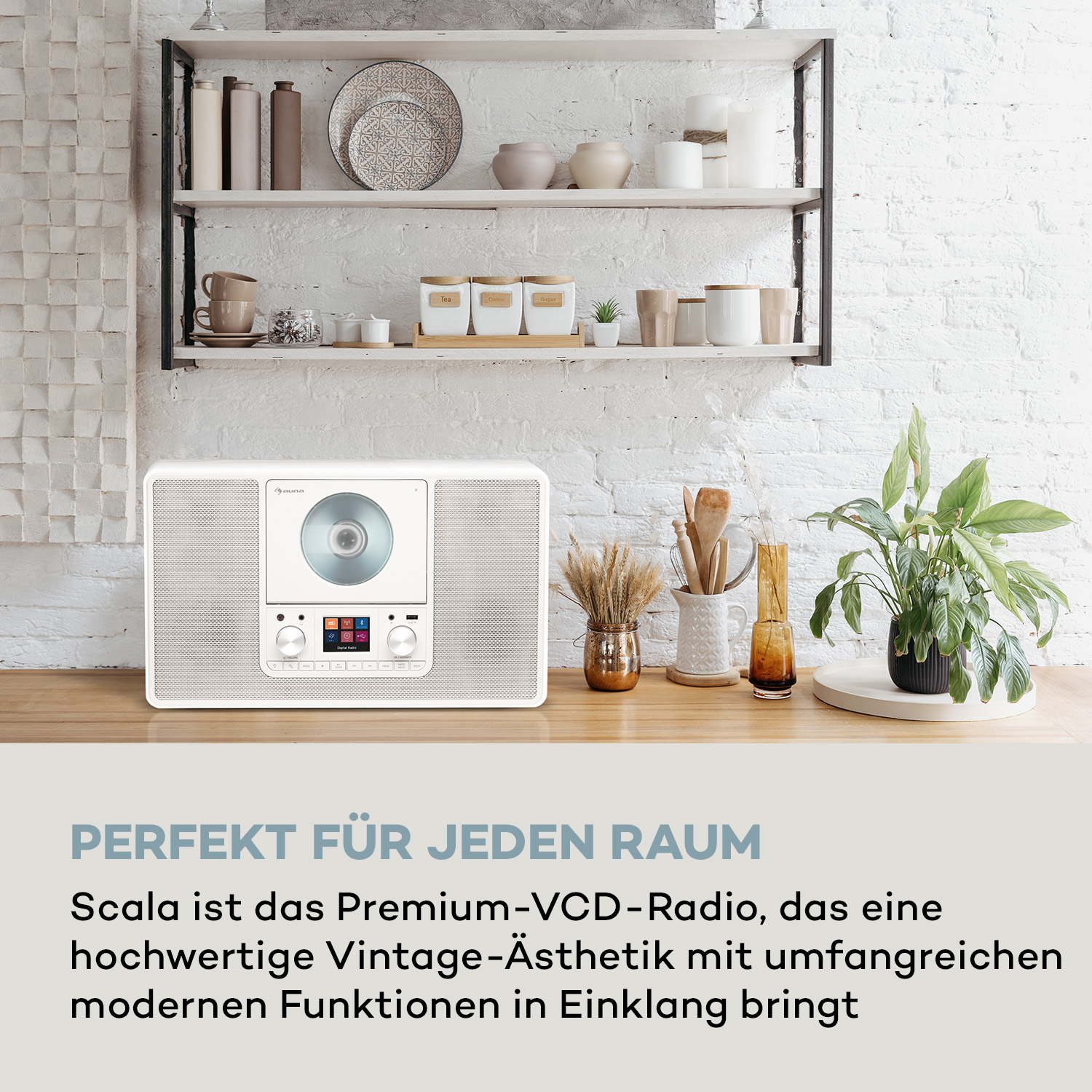 Weißes Radio im Vintage-Stil mit CD-Player und Digitalanzeige. Holzoberfläche mit Pflanzen und Deko im Hintergrund.