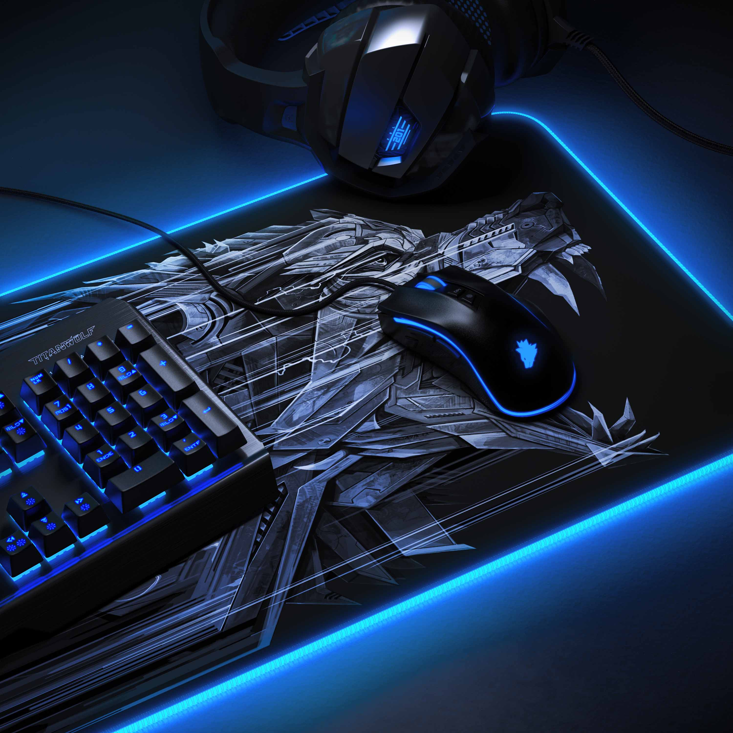 Gaming-Setup mit Tastatur, Maus und Mauspad mit Drachendesign. Blaue Lichter rundherum.