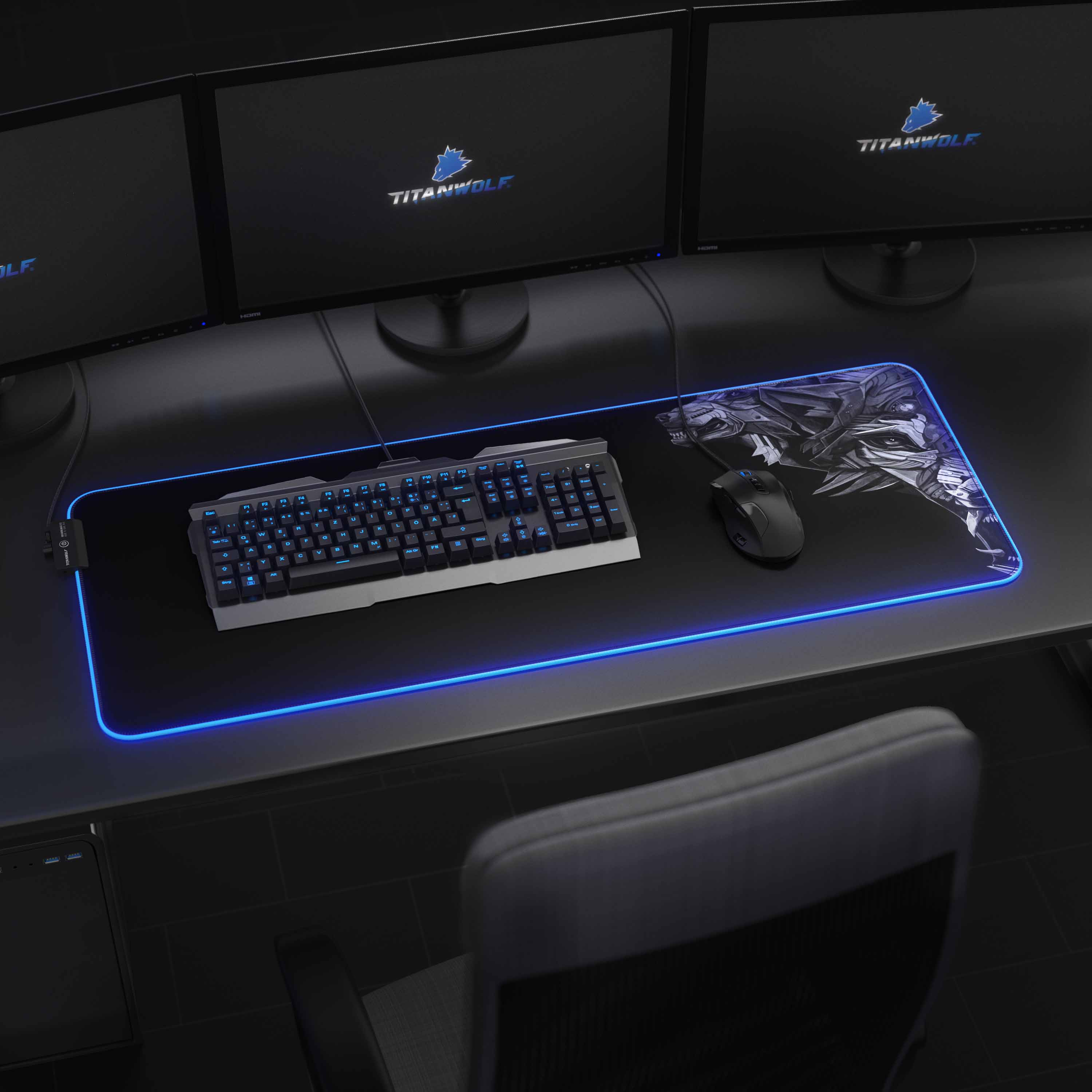 Gaming-Setup mit drei Monitoren, Tastatur, Maus und Mauspad. Blaue Lichter auf dem Mauspad.