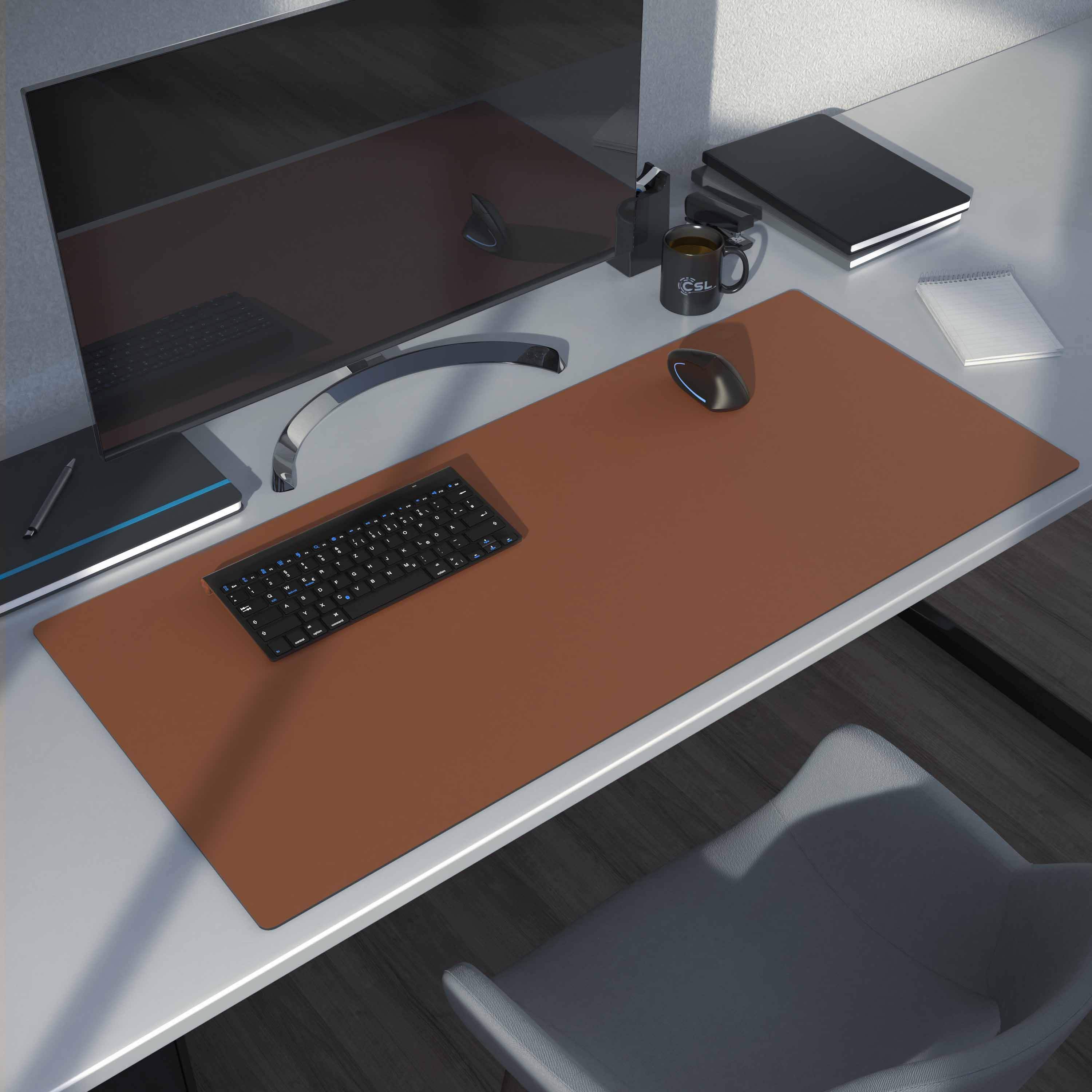 Schreibtisch-Setup mit Tastatur, Maus und Notizblock. Der Schreibtisch ist braun, mit weißem Hintergrund.