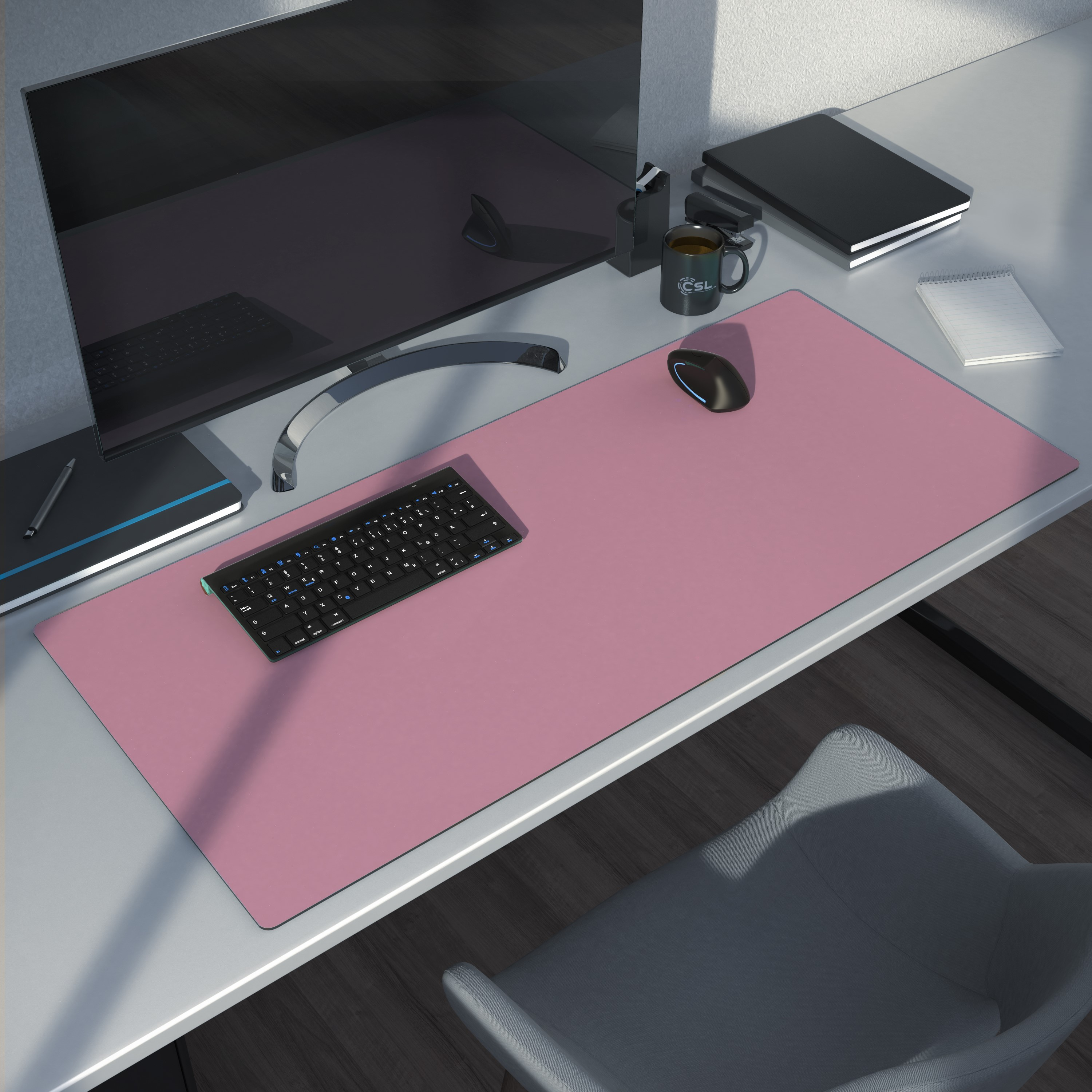 Schreibtisch-Setup mit pinkfarbenem Mauspads, Tastatur, Maus und Monitor. Dunkler Hintergrund.