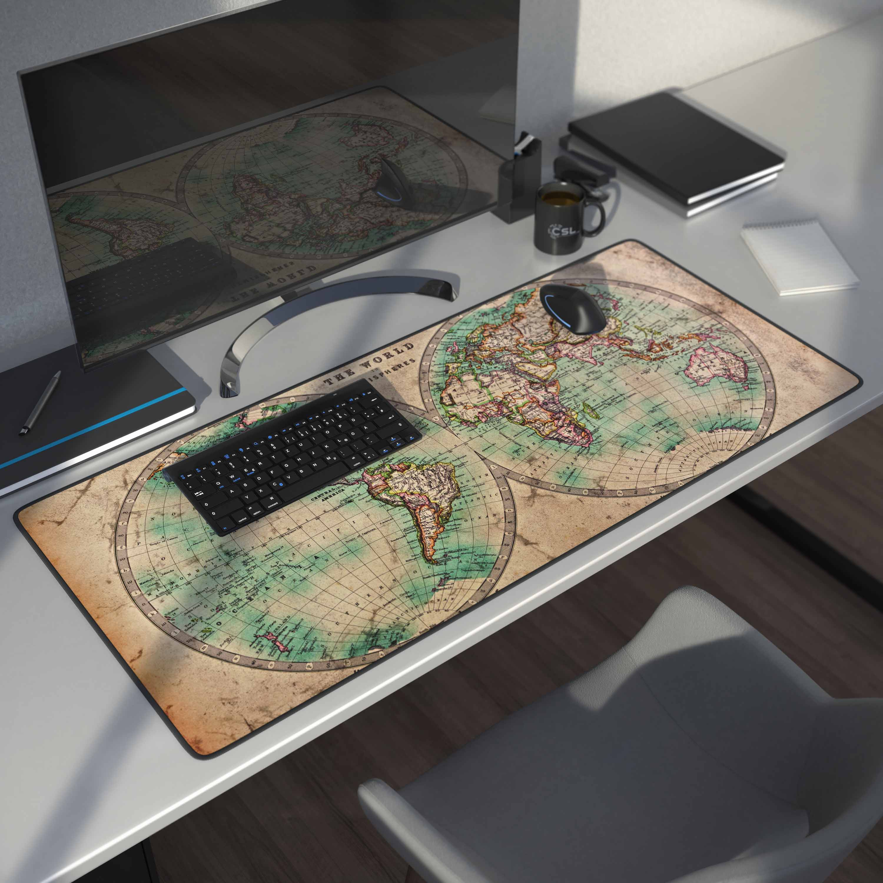 Ein Desktop-Setup mit Tastatur, Maus und Monitor. Das Mauspad hat ein Weltkarten-Design.