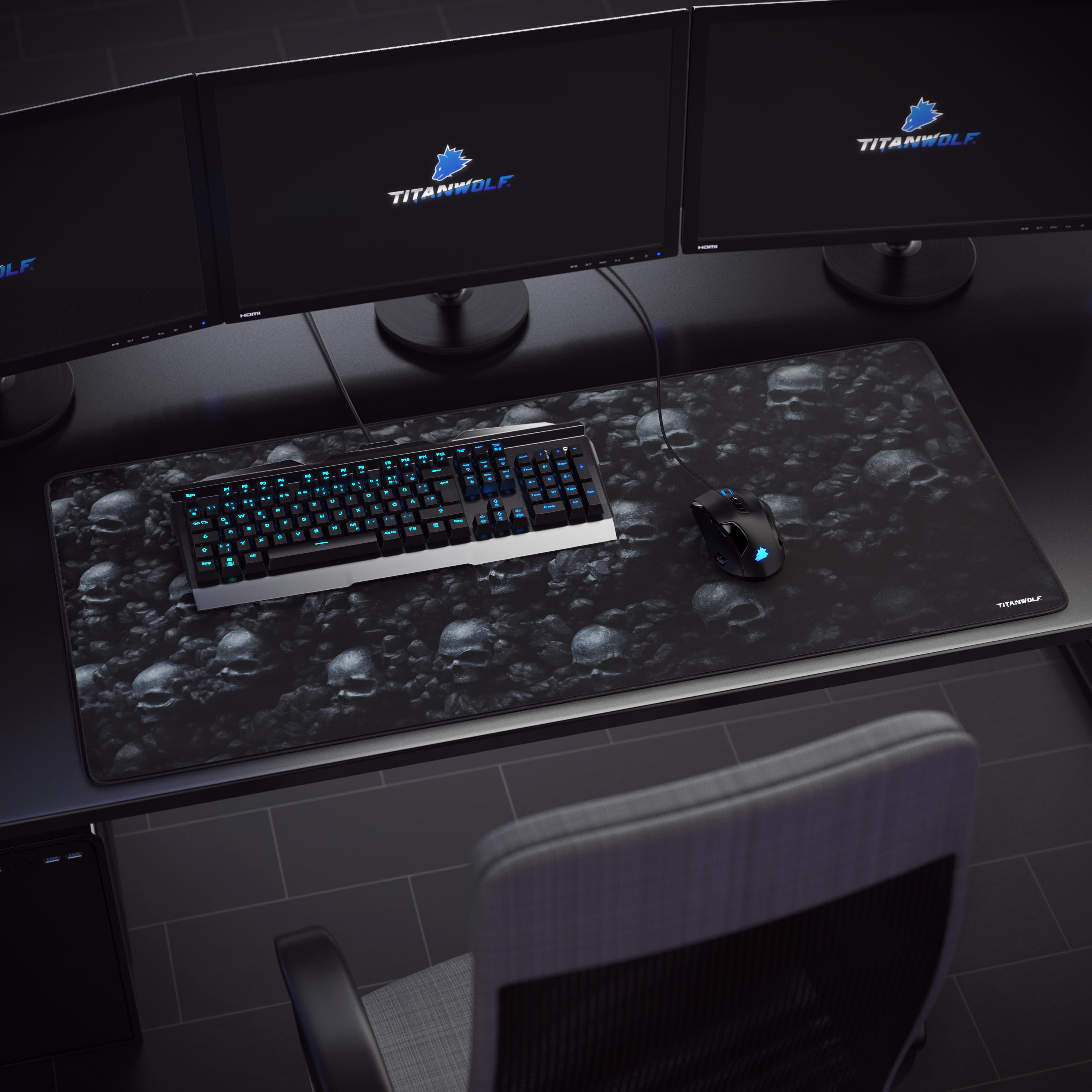 Gaming-Setup mit Tastatur, Maus auf Mauspad mit Totenkopfmuster. Drei Monitore im Hintergrund.