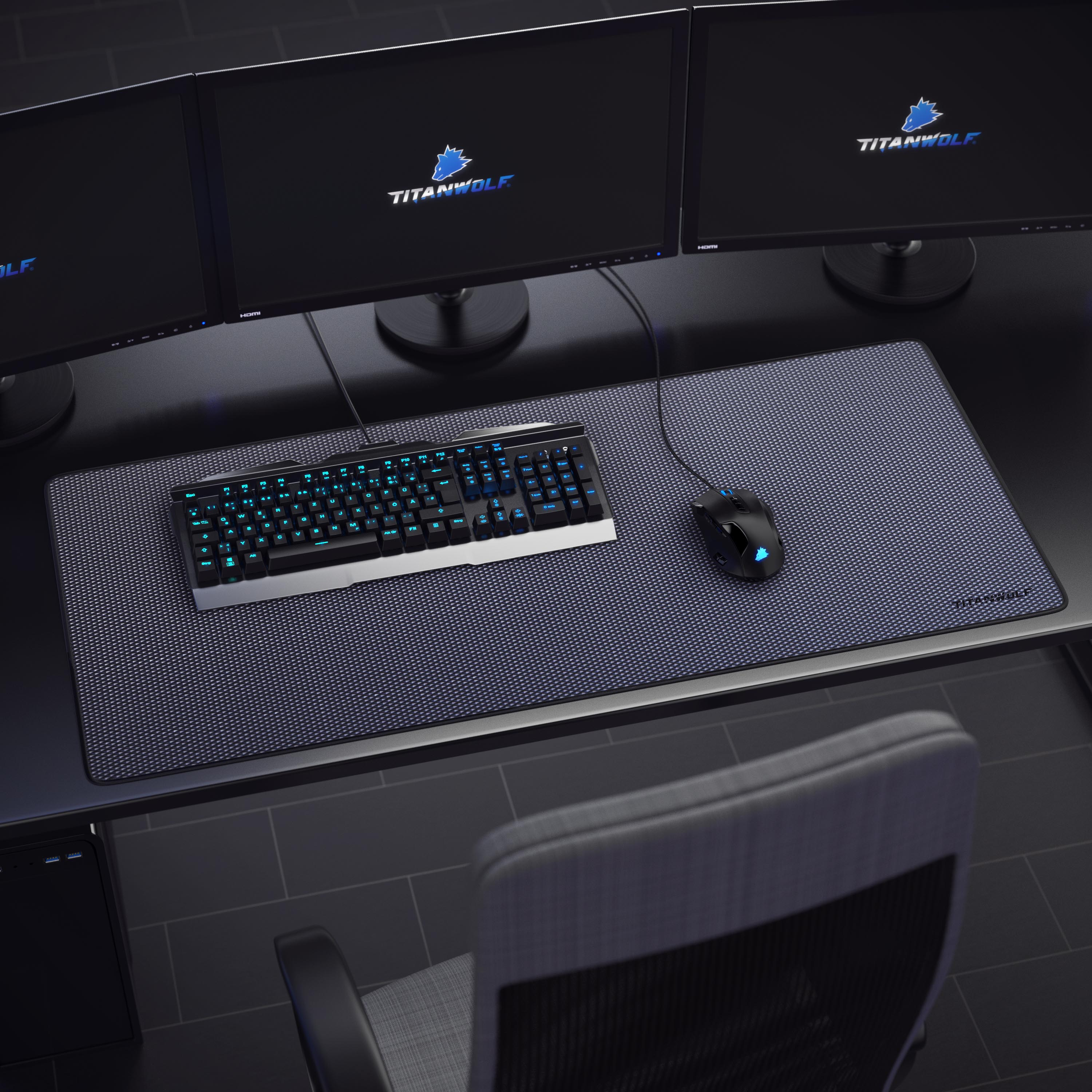 Gaming-Setup mit drei Monitoren, Tastatur und Maus auf einem großen Mauspad. Stuhl im Hintergrund.