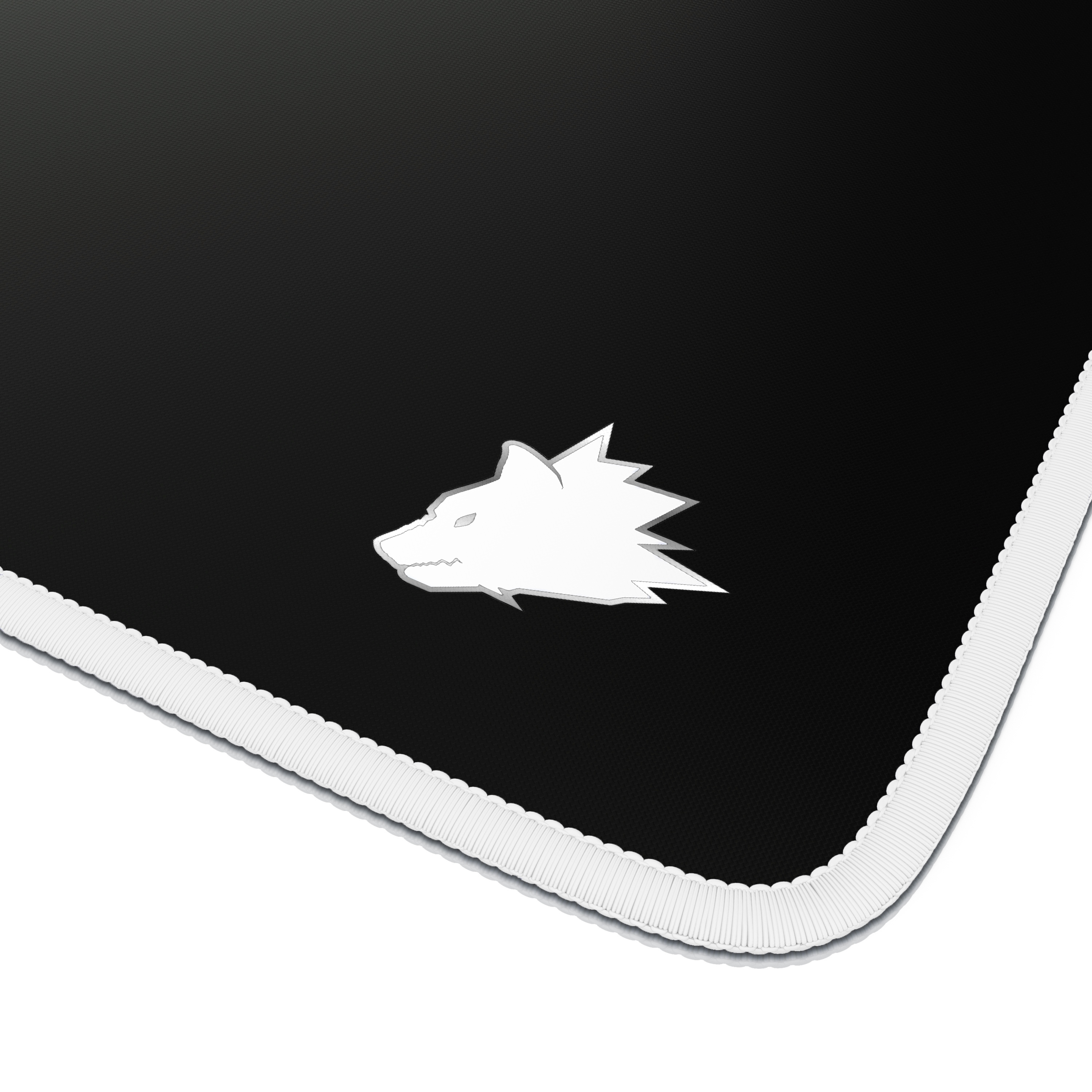 Nahaufnahme eines schwarzen Mauspads mit weißem Wolfslogo. Die Ränder sind weiß mit einem genähten Design.