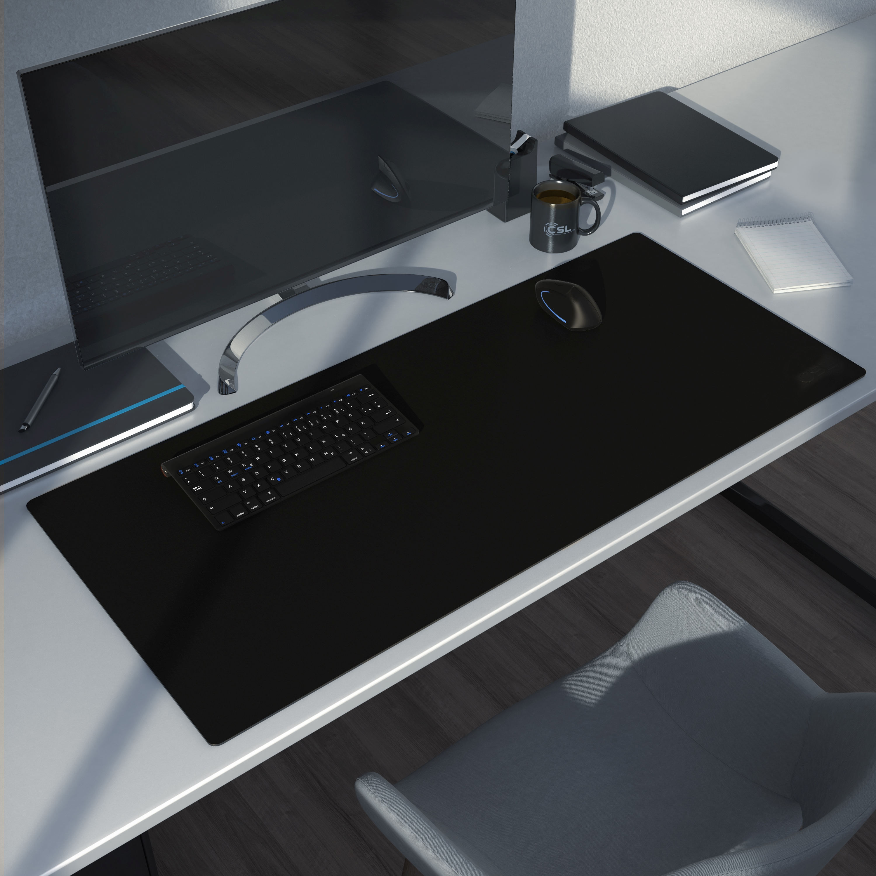 Schreibtisch-Setup mit Monitor, Tastatur, Maus auf schwarzem Mauspad und einer Tasse.