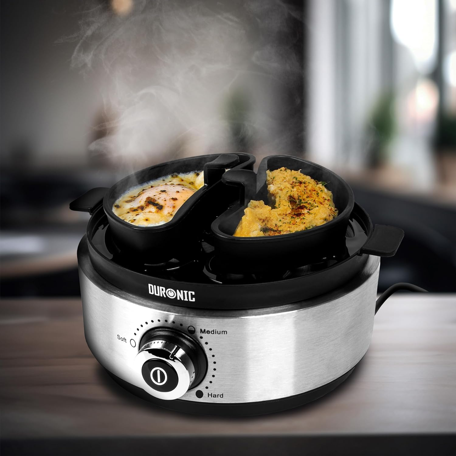 Cocedor de huevos con dos compartimentos, cada uno con un huevo. Vapor subiendo y un mando.