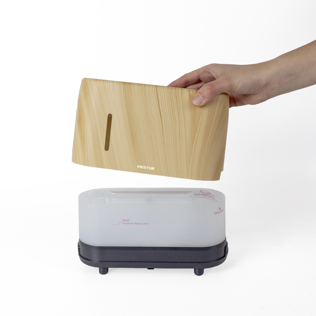 Drewniana góra nawilżacza jest podnoszona z podstawy. Podstawa jest biało-czarna.