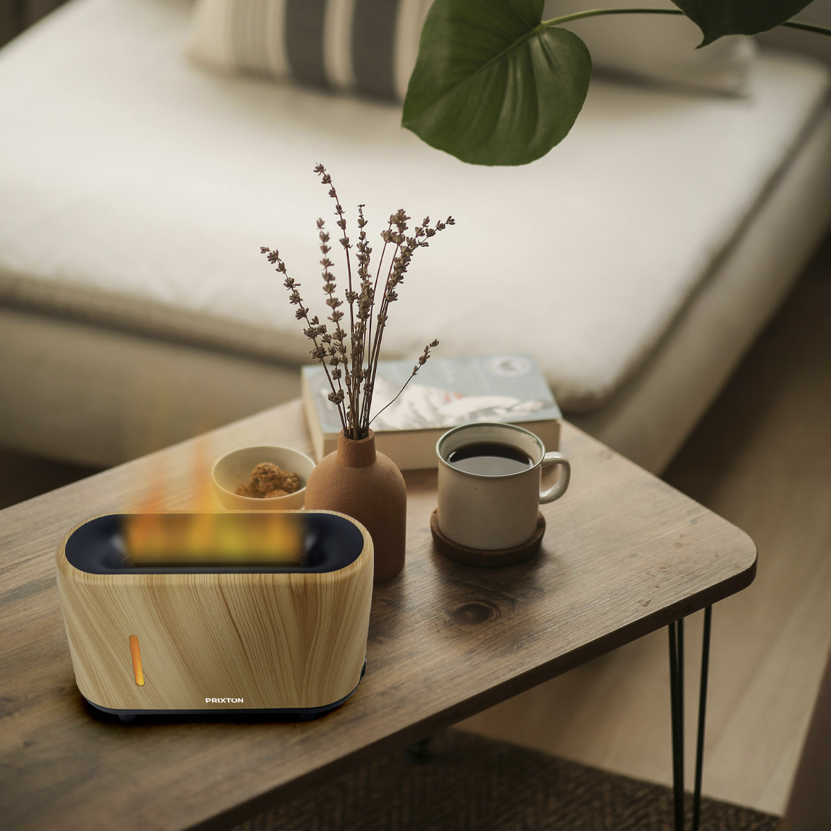 Elektryczny grzejnik o wyglądzie drewna na stole, z kubkiem, kwiatami i książką. Ciepłe kolory.