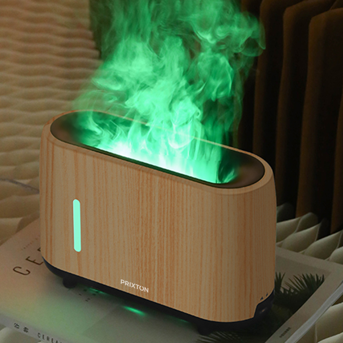 Drewniany dyfuzor aromatu z zieloną mgłą wydobywającą się z góry, na książce na łóżku.