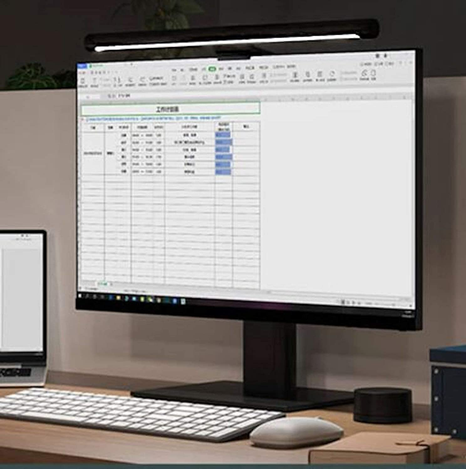 Ustawienia biurka z monitorem, klawiaturą i lampą. Arkusz kalkulacyjny na ekranie.