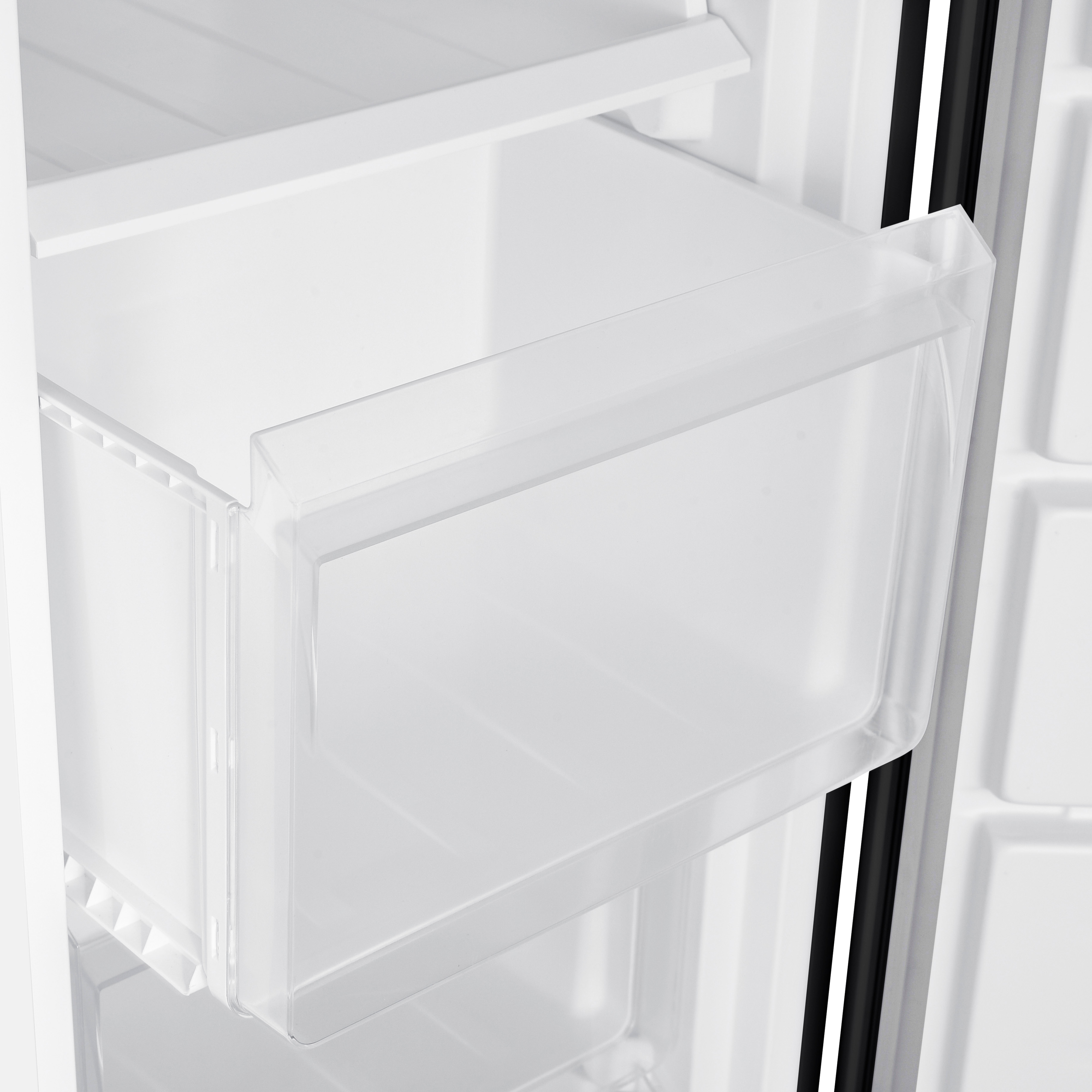 Close up of a white freezer drawer, inside a freezer.