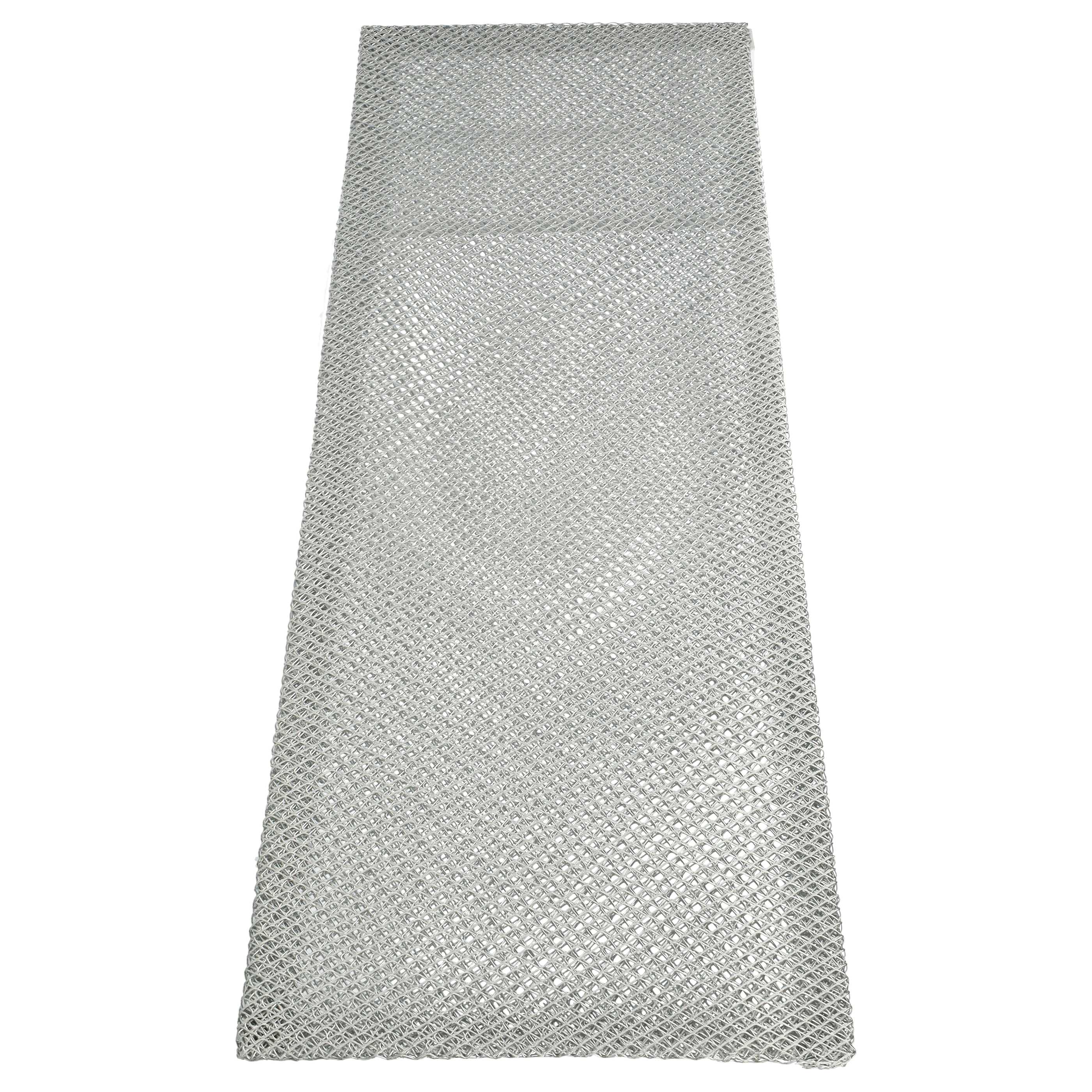 Ein rechteckiger Metallfilter mit einem rautenförmigen Maschenmuster, aus niedriger Perspektive vor weißem Hintergrund gesehen.