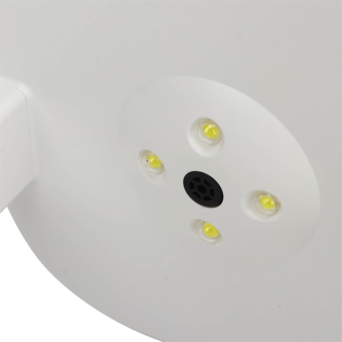 Weiße kreisförmige Lampe mit vier gelben LEDs. Ein schwarzes Mittelloch ist sichtbar.