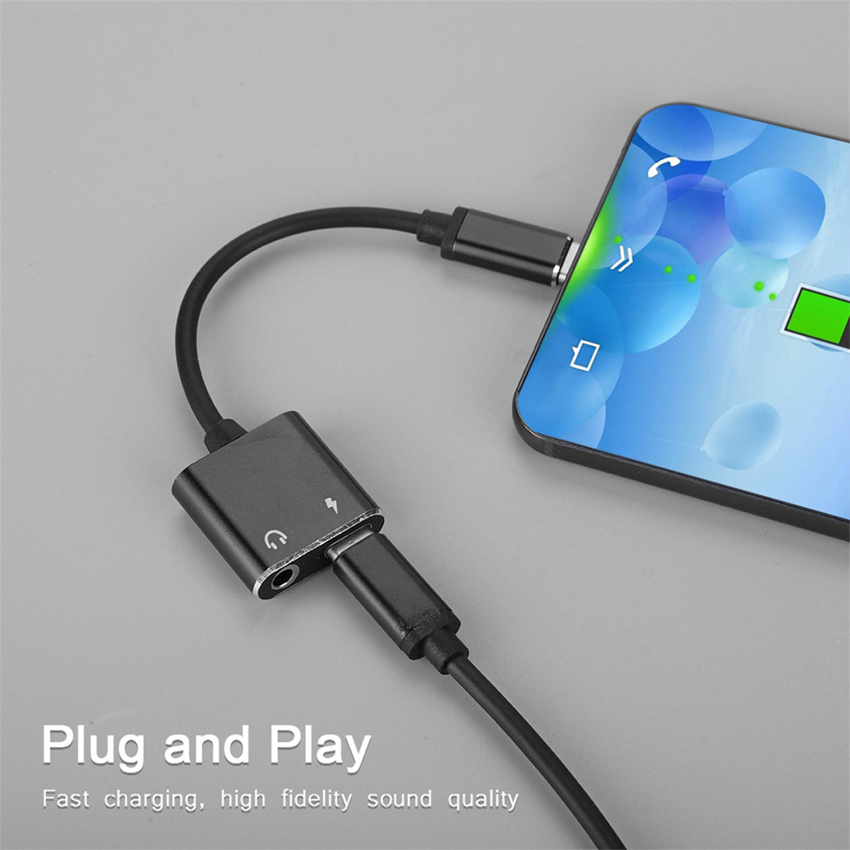 Schwarzer Audioadapter, der ein Telefon mit Kopfhöreranschluss und Ladeanschluss verbindet.