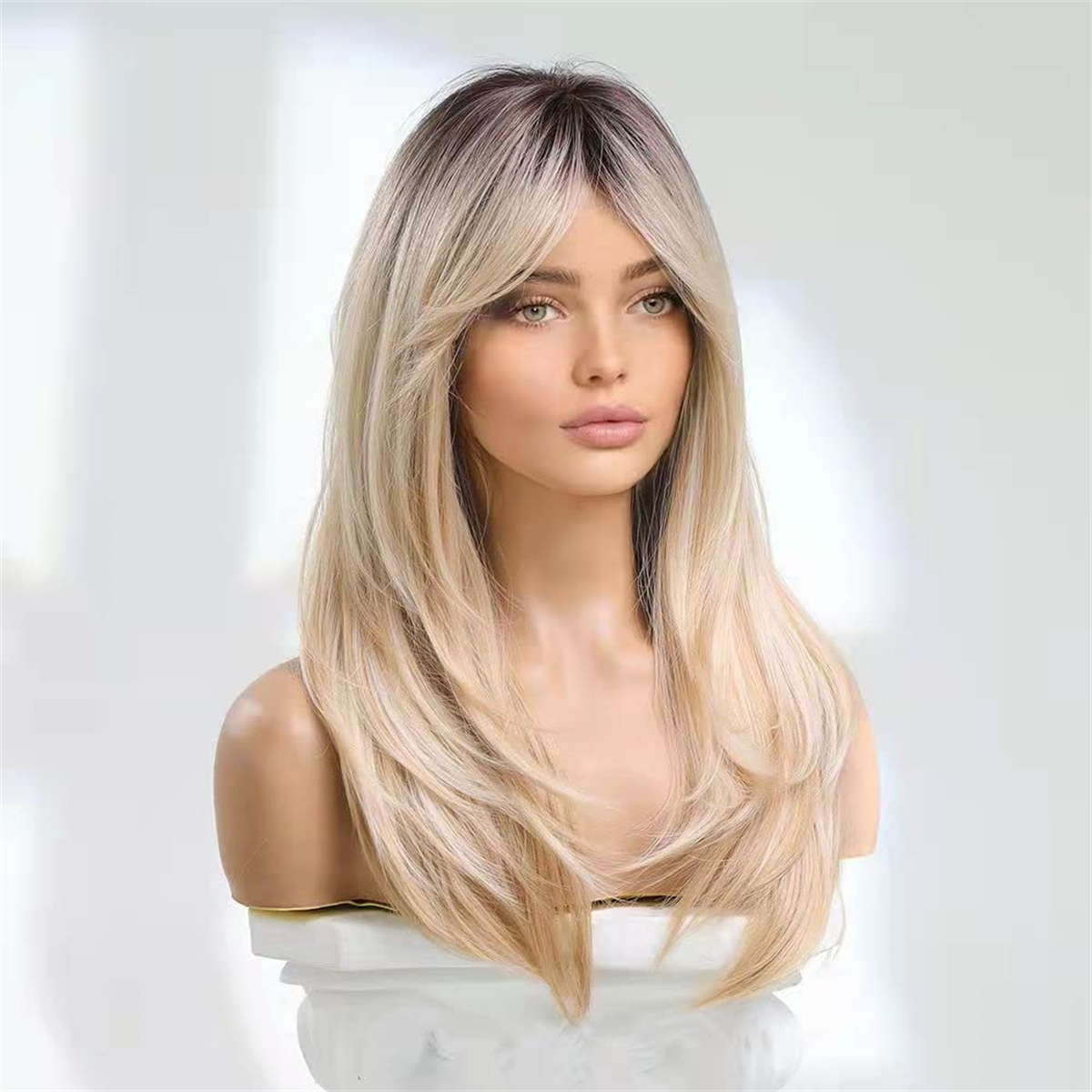 Frau mit Perücke. Sie hat blondes und braunes Haar. Die Frau ist auf weißem Hintergrund.