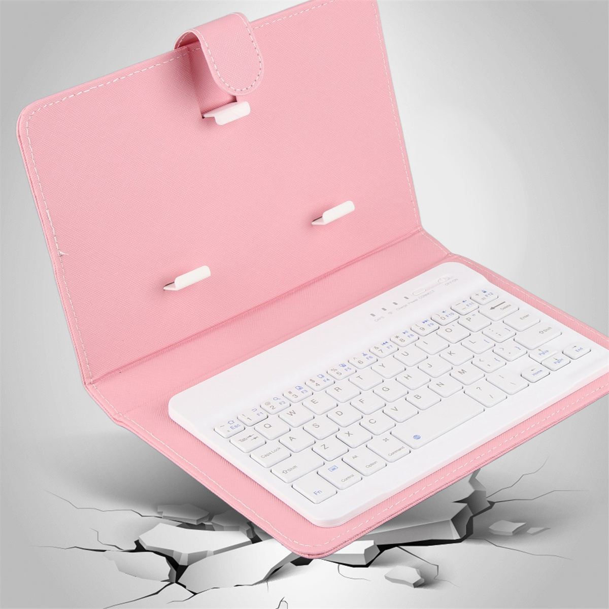 Rosa Tablethülle, offen, mit weißer Tastatur. Der Hintergrund zeigt Risse.