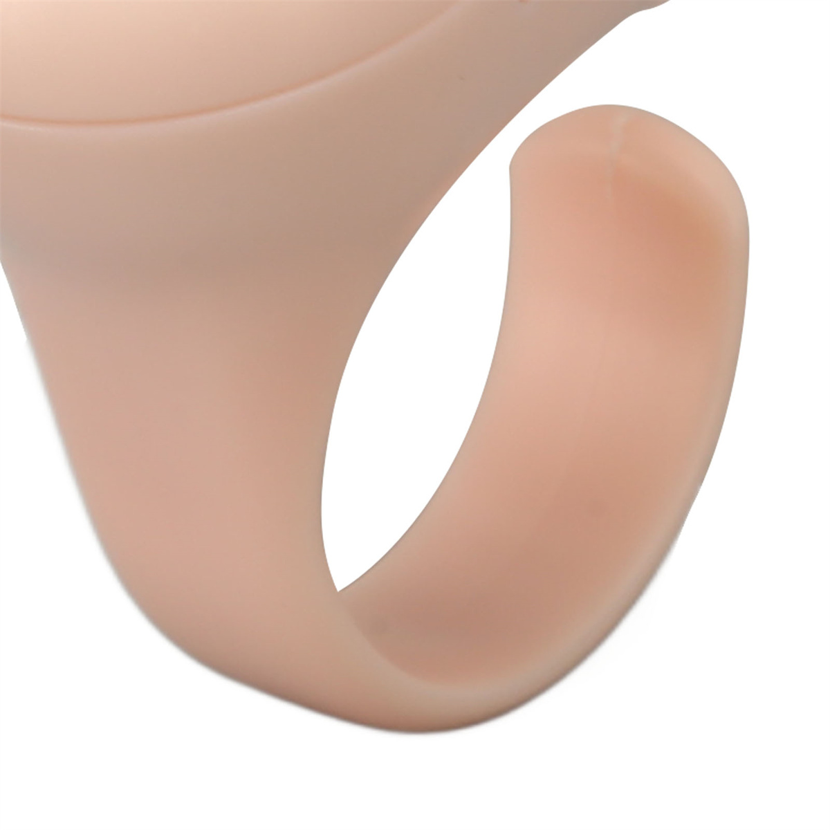 Nahaufnahme eines hautfarbenen Silikonrings mit abgerundeter Form, vor weißem Hintergrund.