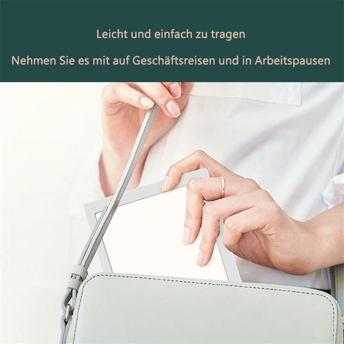Hände halten ein weißes Tablet, das in eine graue Handtasche greift.