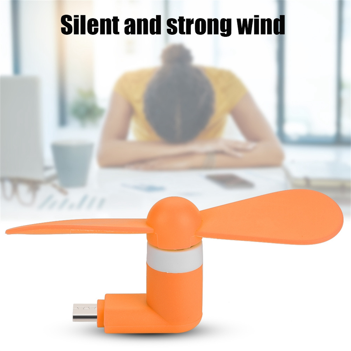 Oranger Mini-Ventilator mit USB-Anschluss unten und verschwommenem Hintergrund.